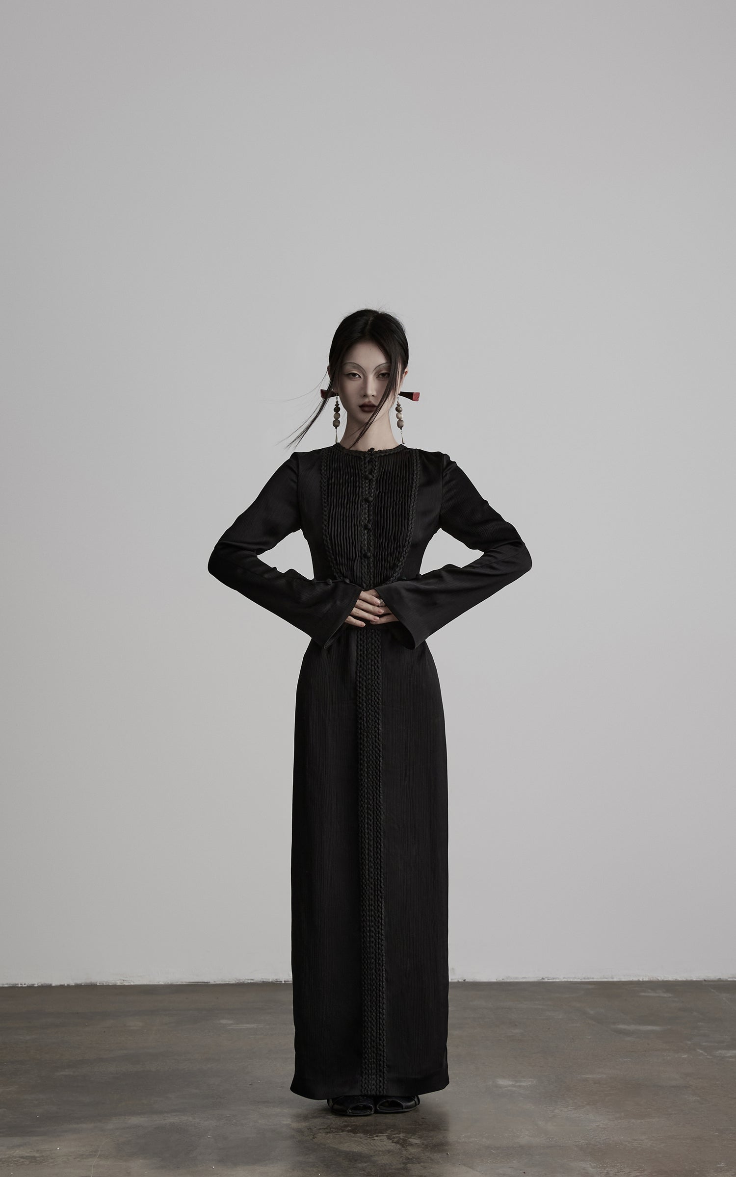 <tc>DOINDULGE</tc> Plissiertes Kleid mit geflochtenem Taillenbund, langen Ärmeln und skulpturalem Maxi-Schnitt