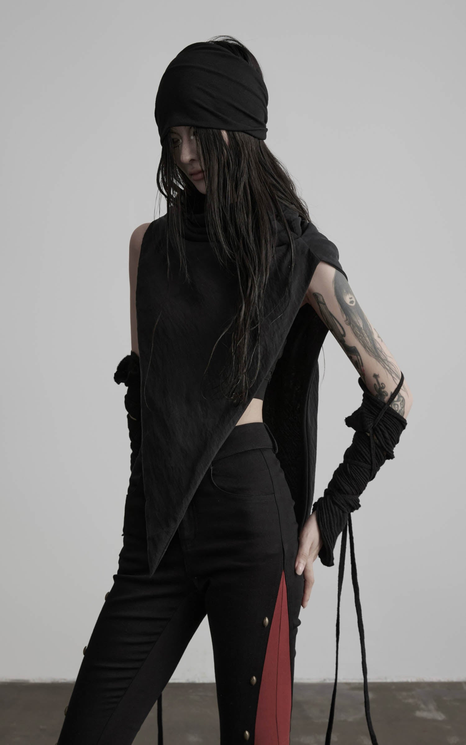 Angled view of black asymmetric drape scarf shawl with pointed asymmetrical panel