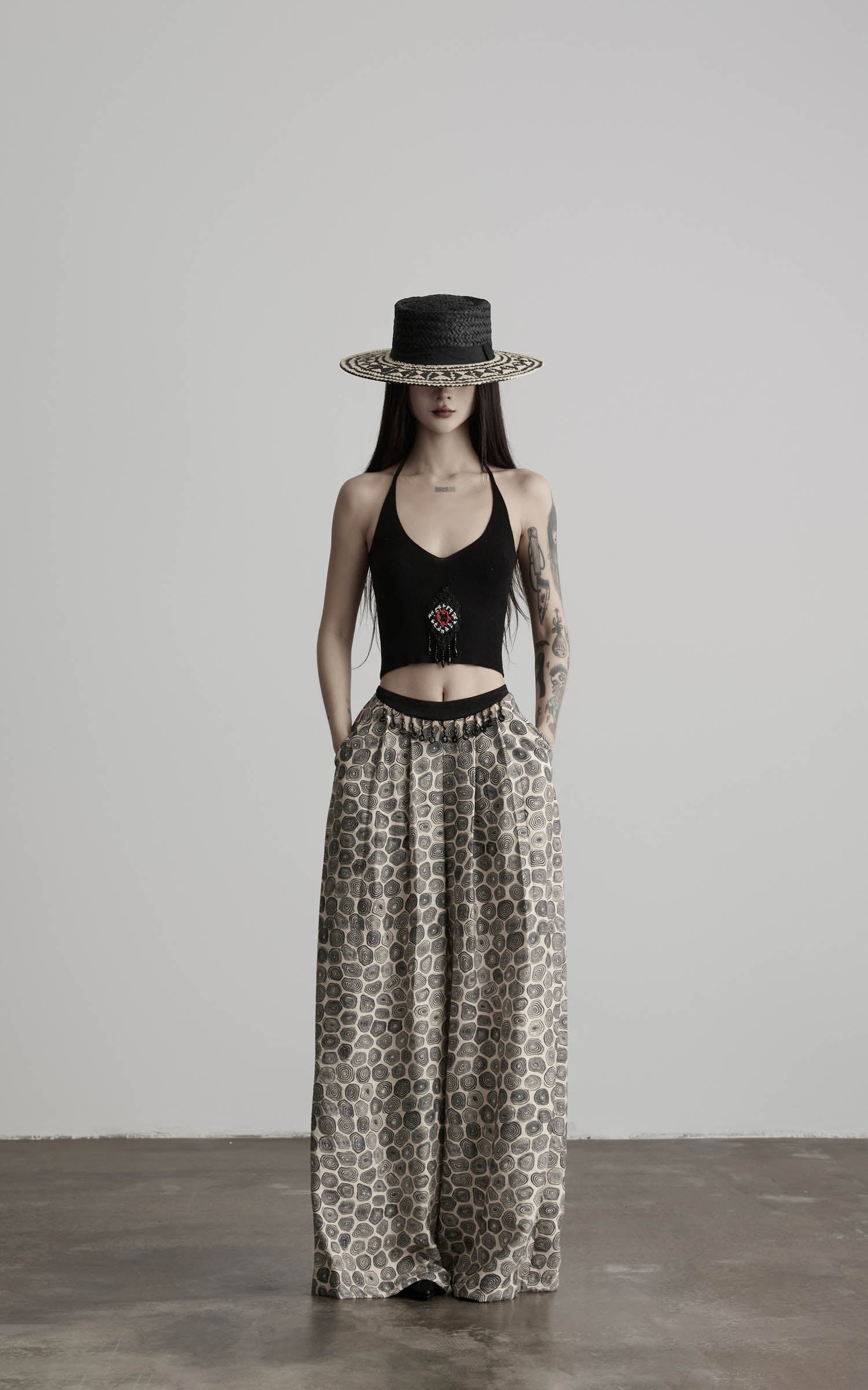 front view of black beaded halter knit top with fitted waistline