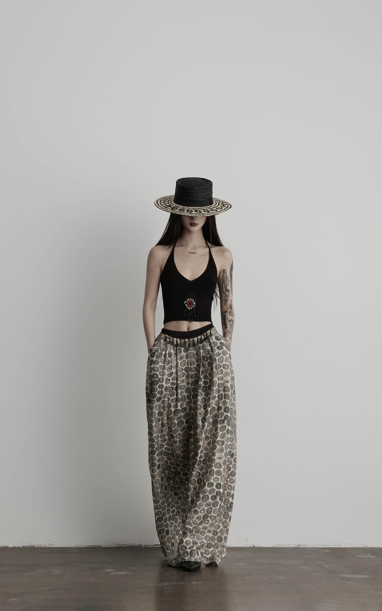 front view of black beaded halter knit top with elongated silhouette