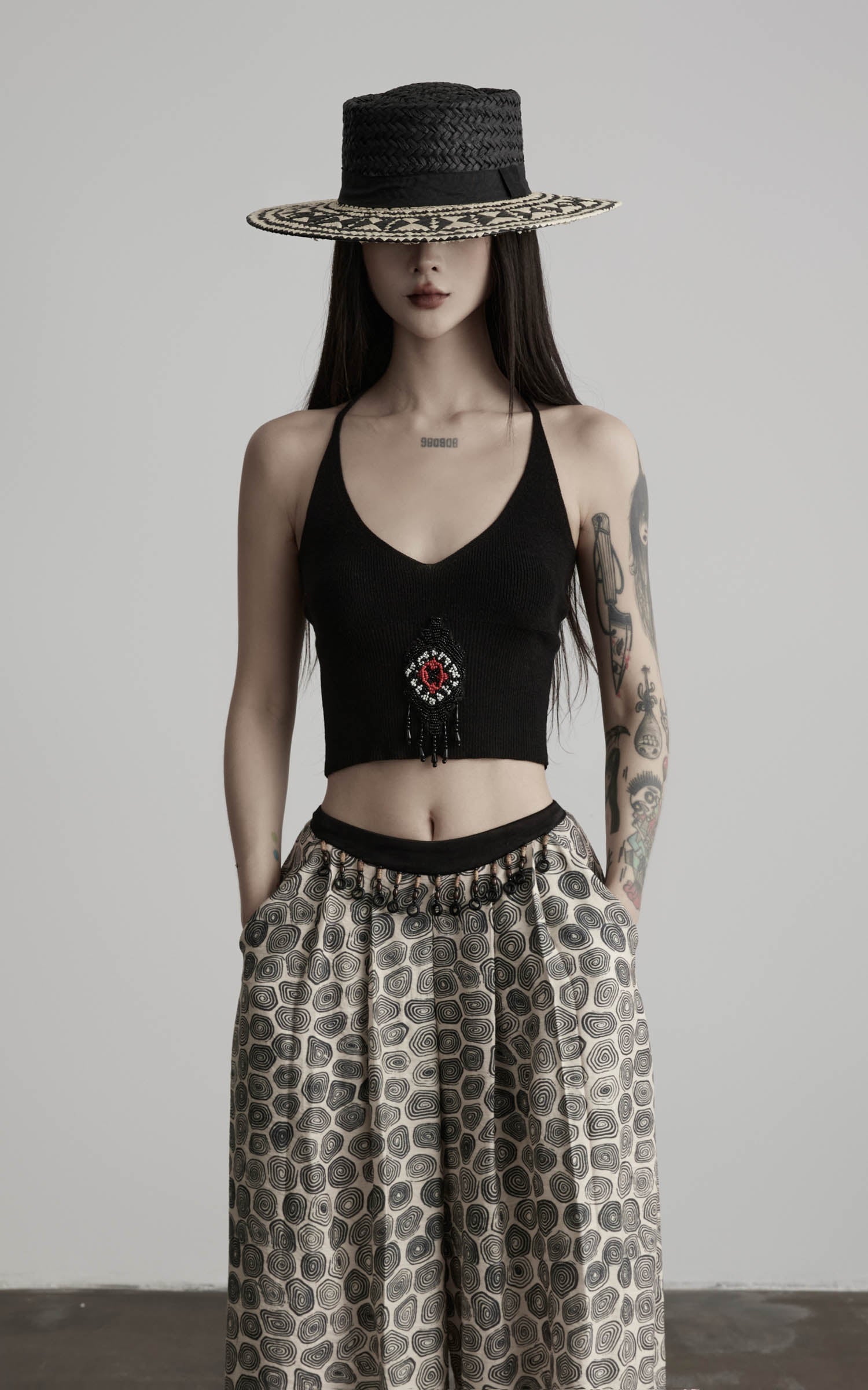 front view of black beaded halter knit top with v-neck cropped silhouette
