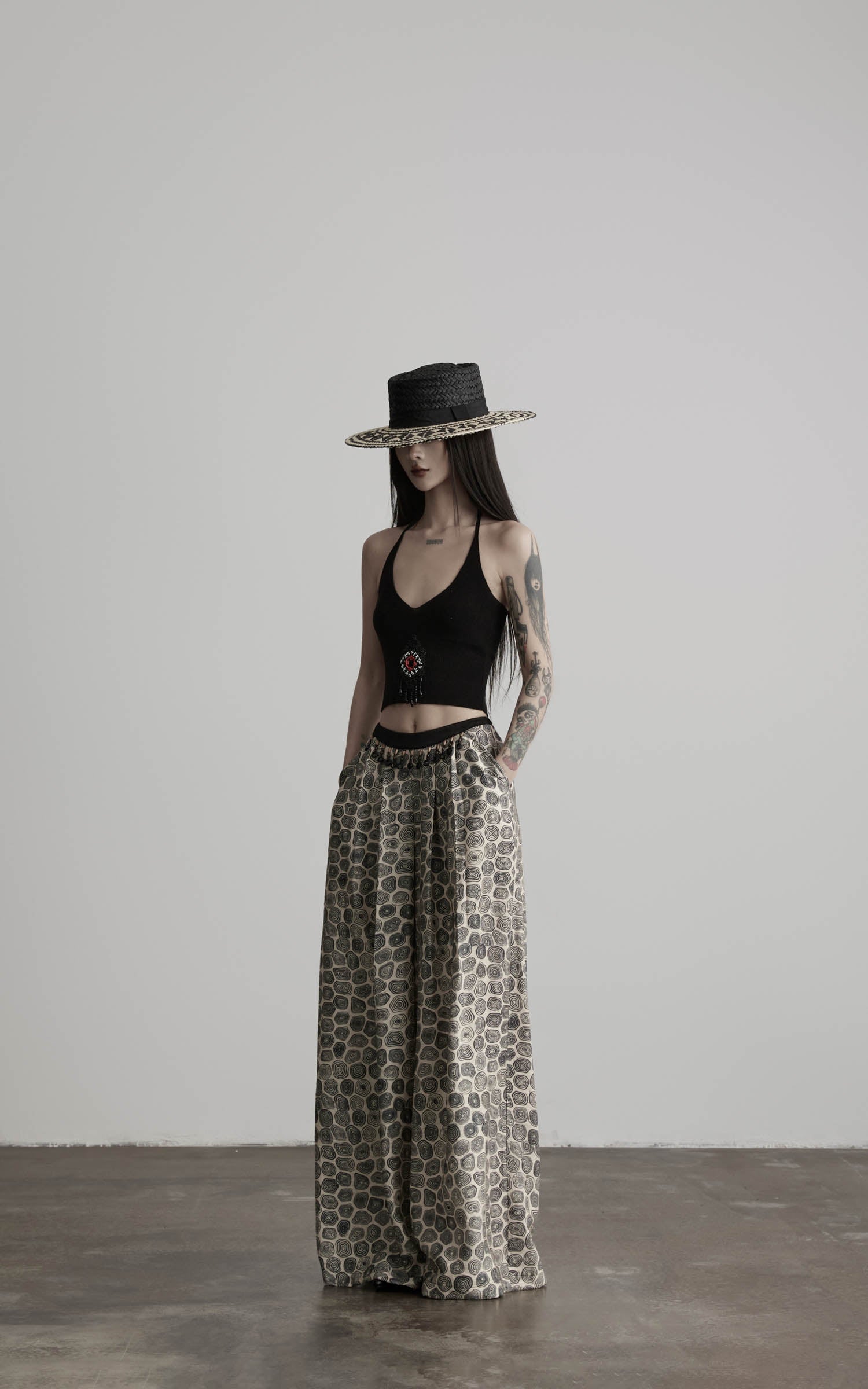 side view of black beaded halter knit top with soft draped fit