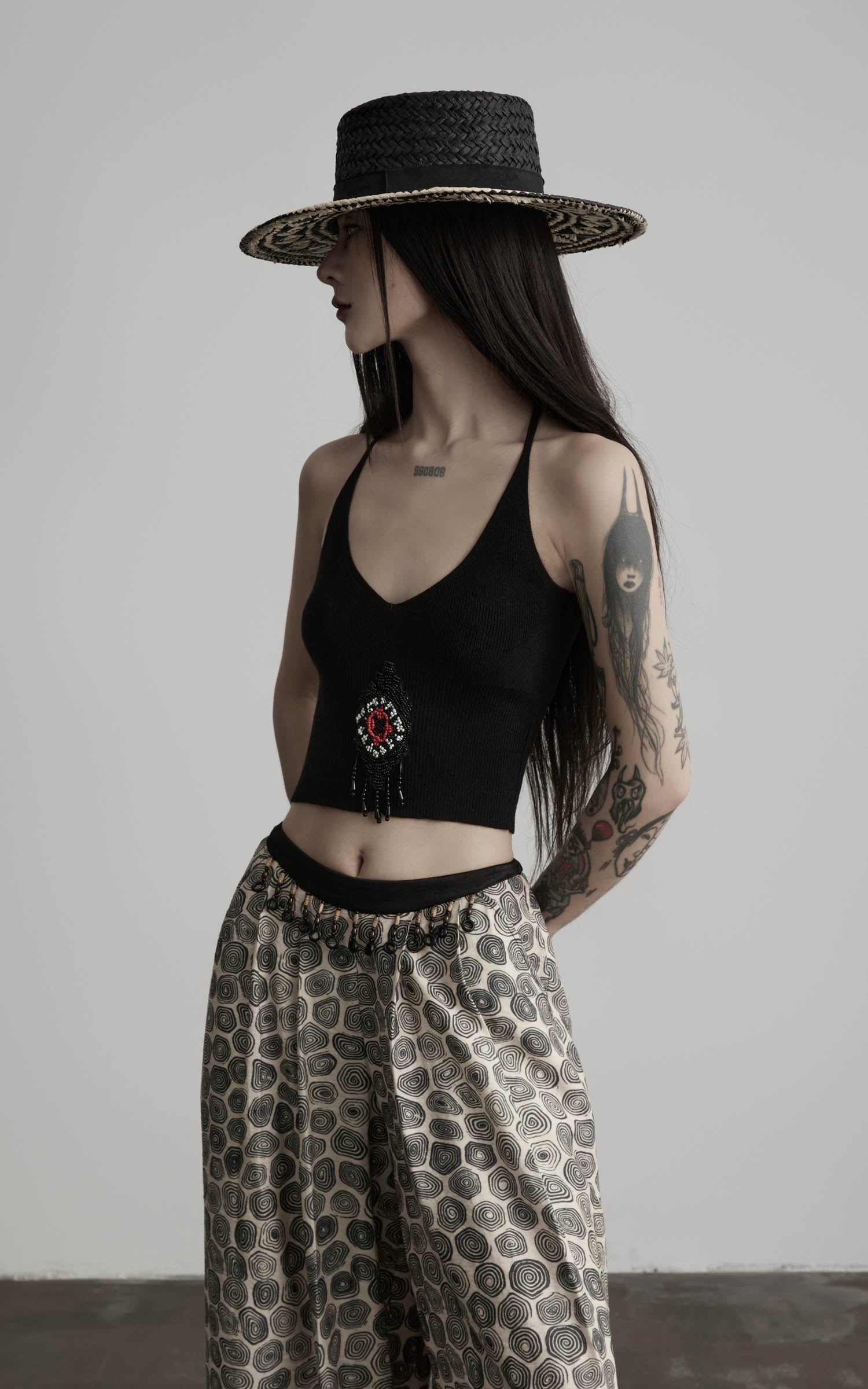 side view of black beaded halter knit top with ribbed cropped fit