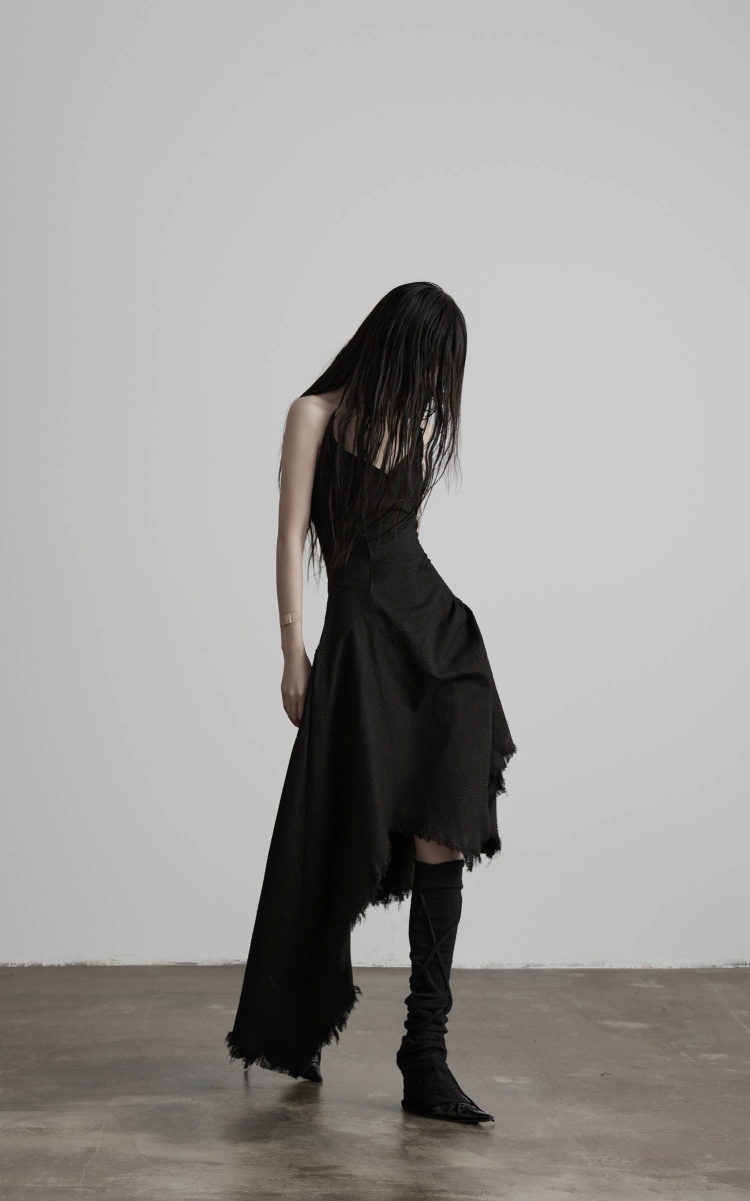 Black cotton bustier dress with uneven skirt drape side view