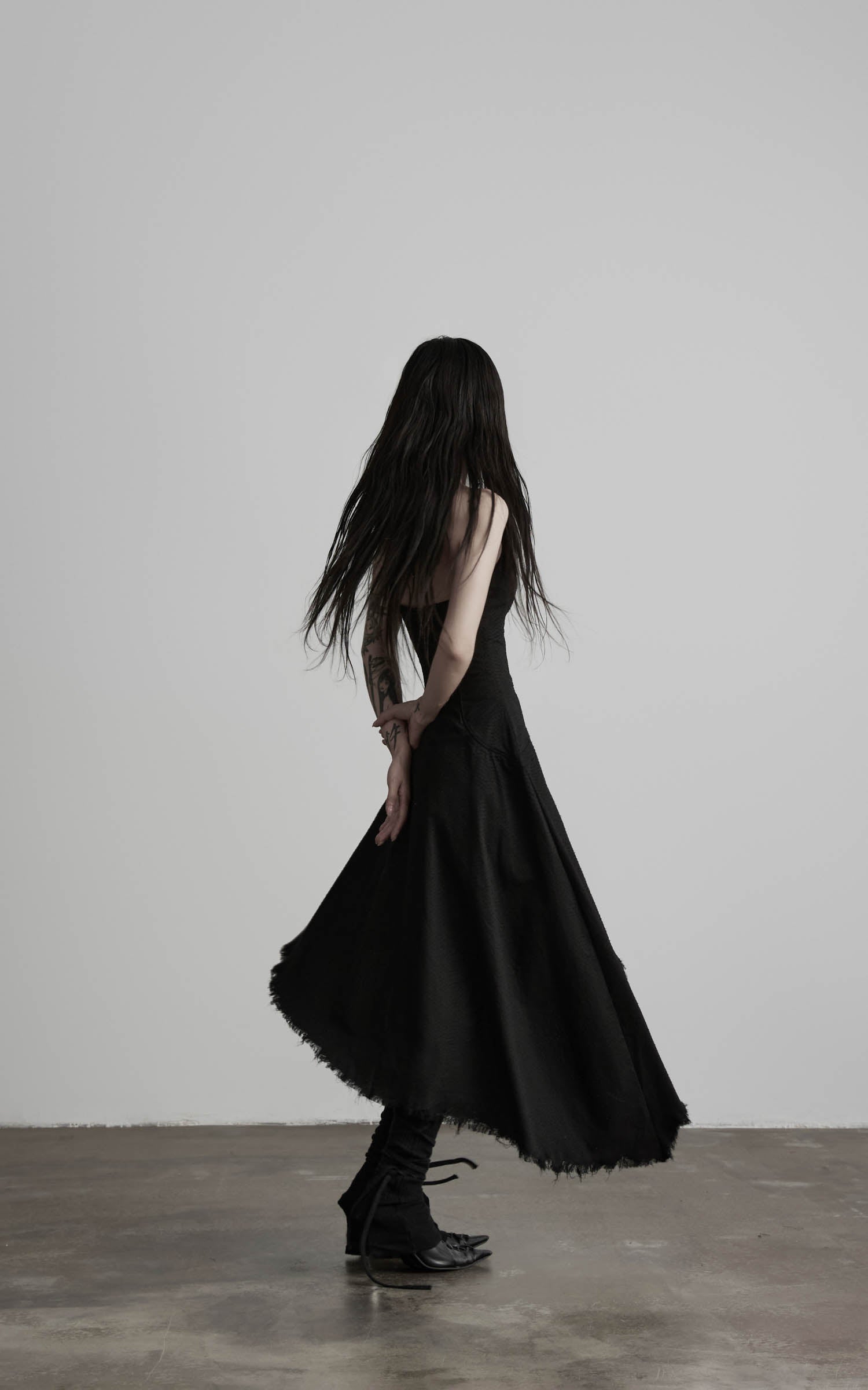 Black cotton bustier dress with flared skirt movement side view
