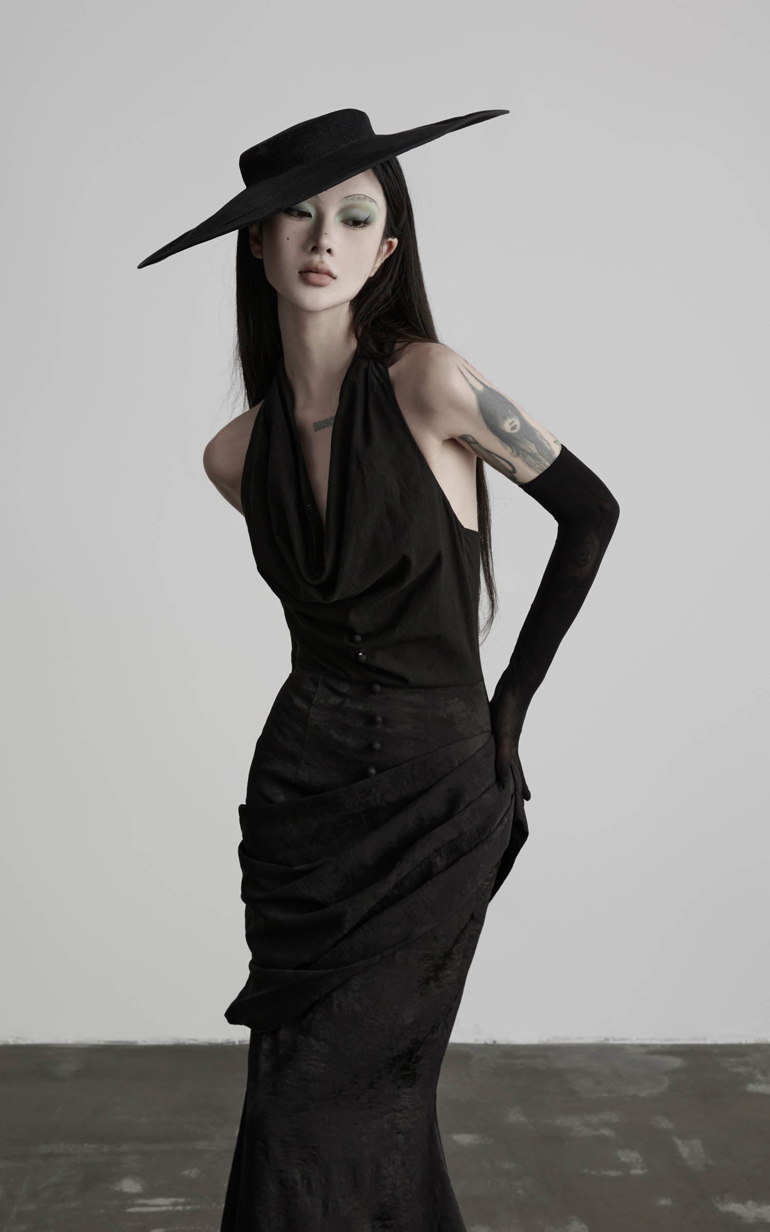 Black halter cowl neck maxi dress with draped waist close-up view