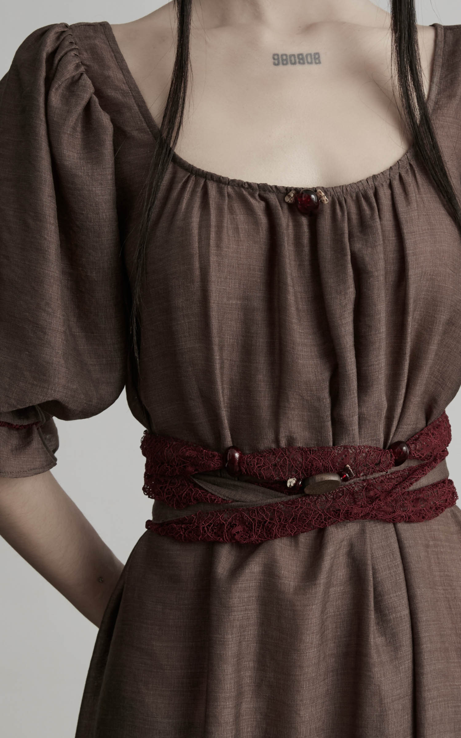 close-up of brown maxi dress with gathered neckline and waist tie