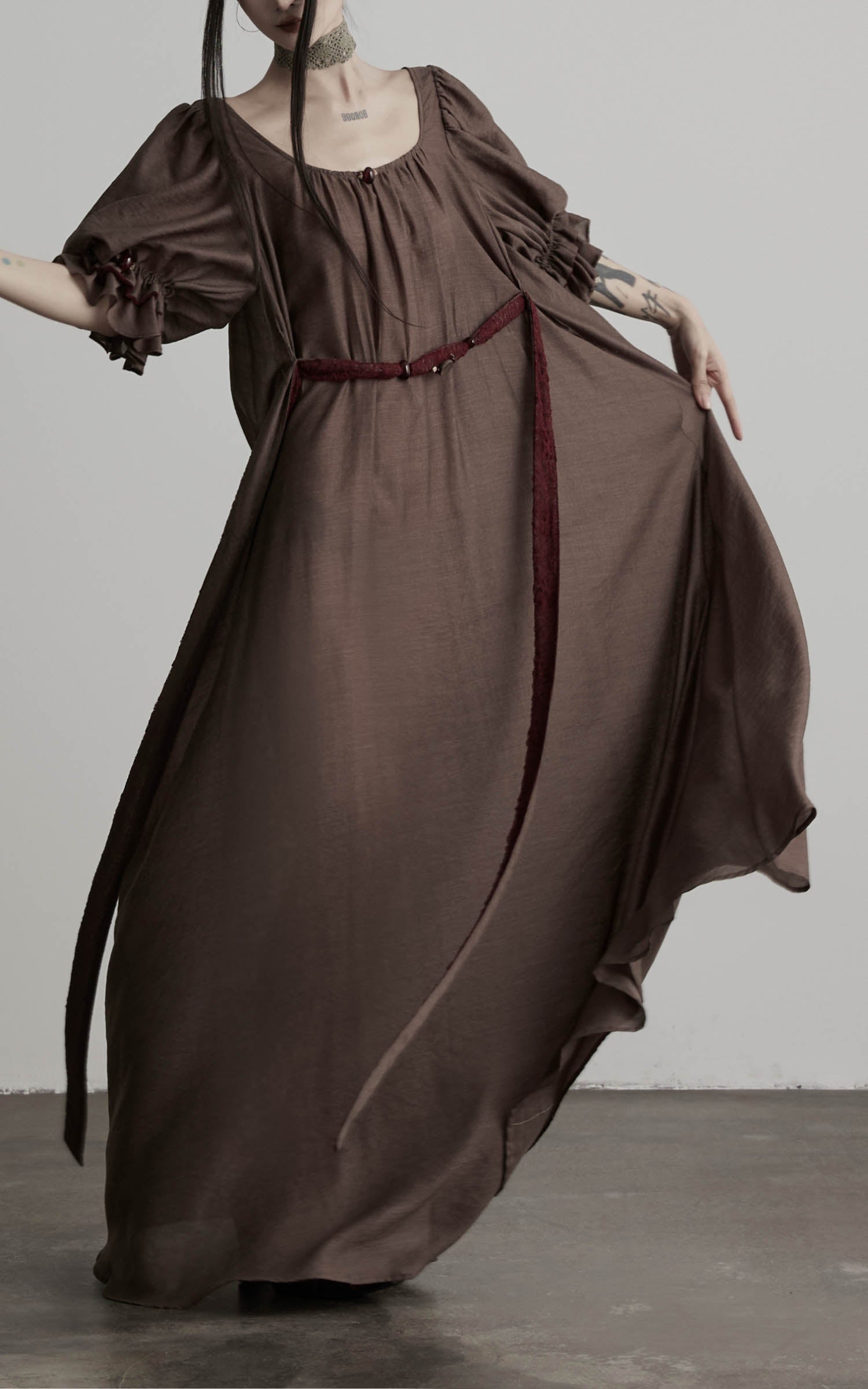 close-up of brown maxi dress with flowing hem and fabric movement