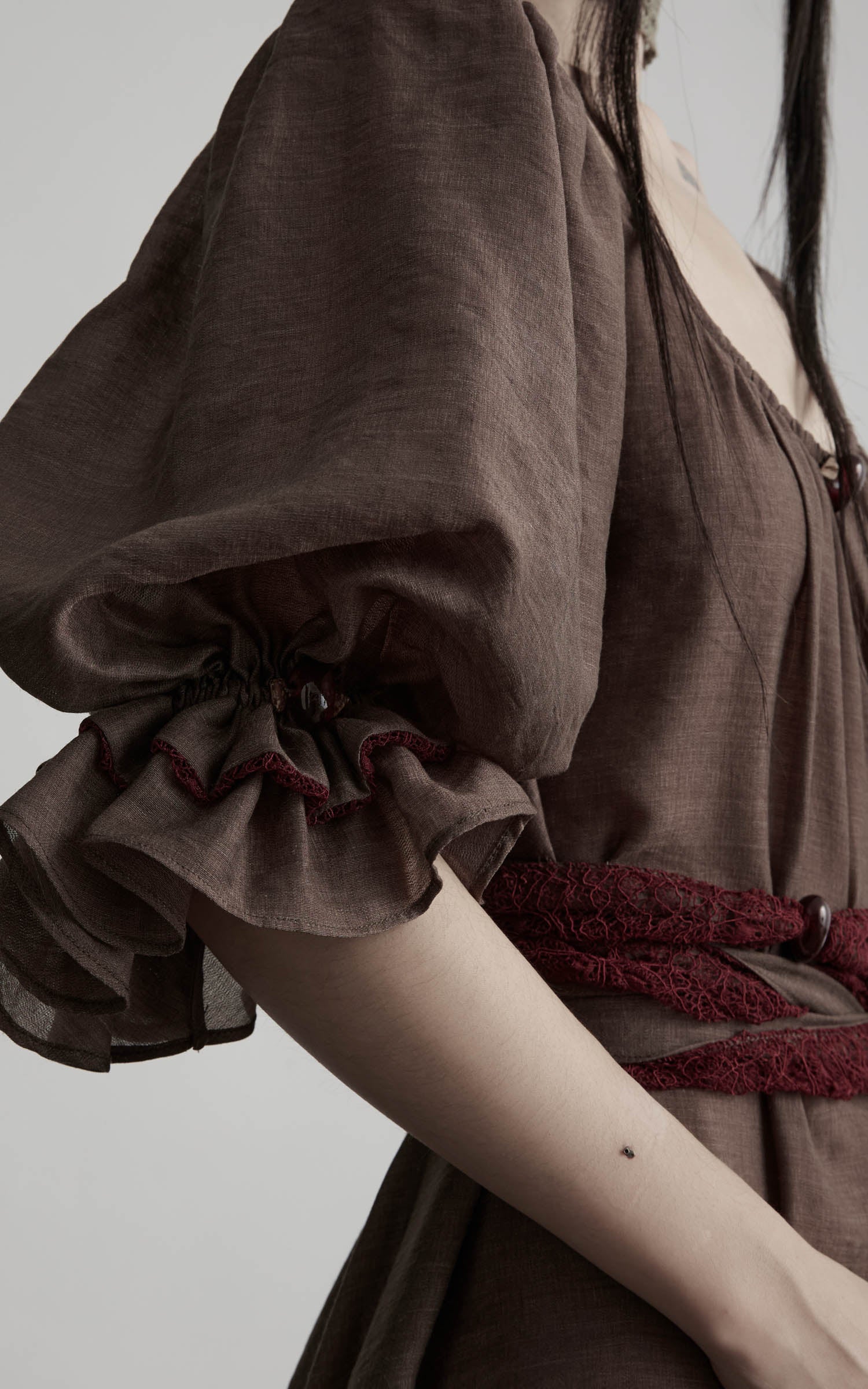 close-up of brown maxi dress with gathered sleeve and soft texture