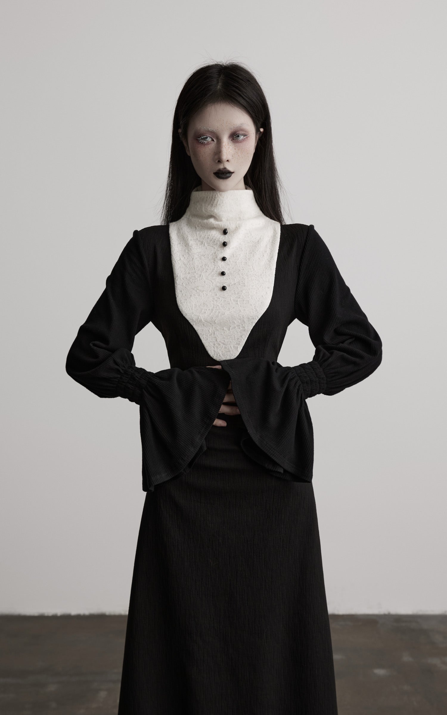 front view of black contrast panel high neck dress with defined waist