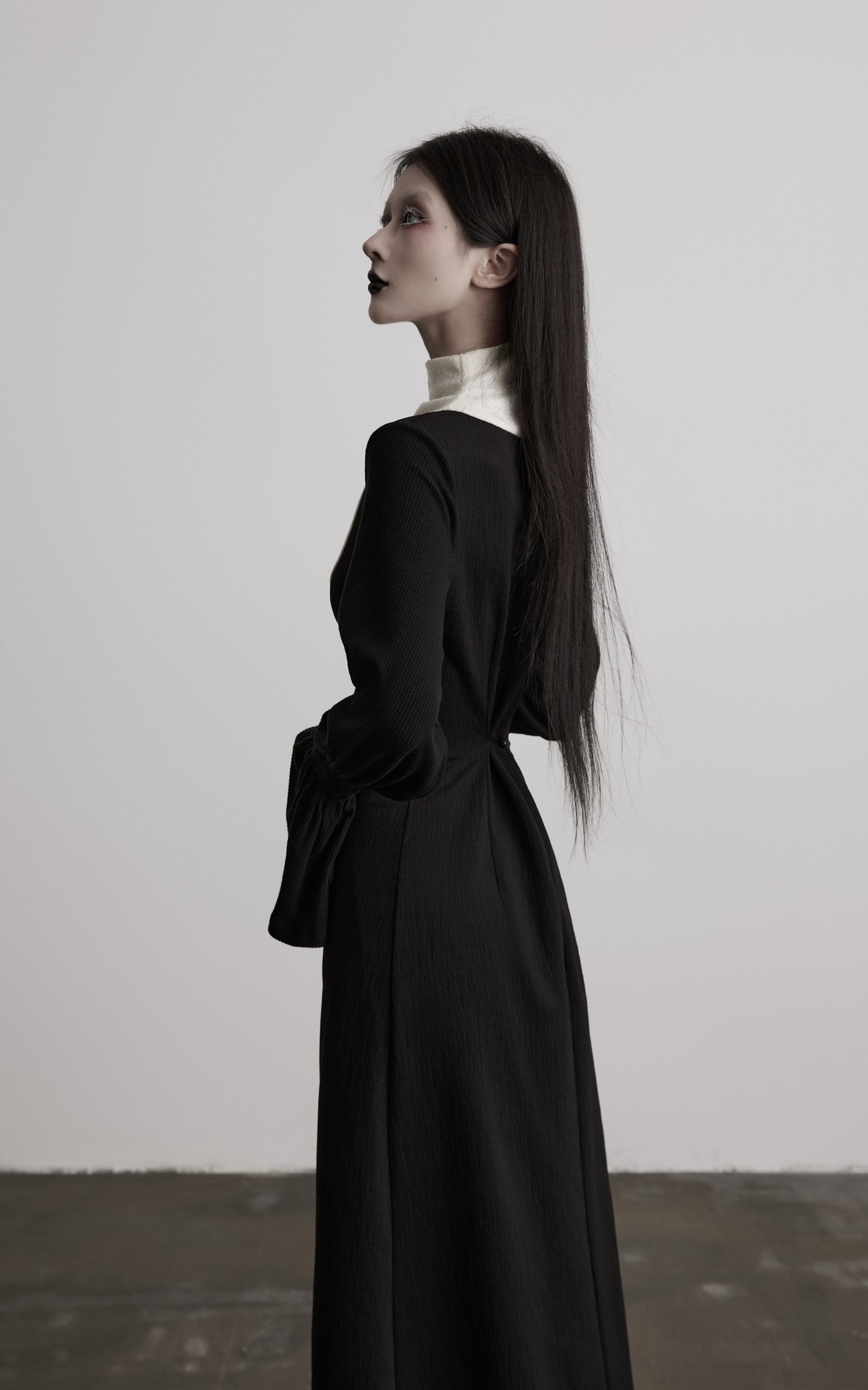 side view of black contrast panel high neck dress with fitted silhouette