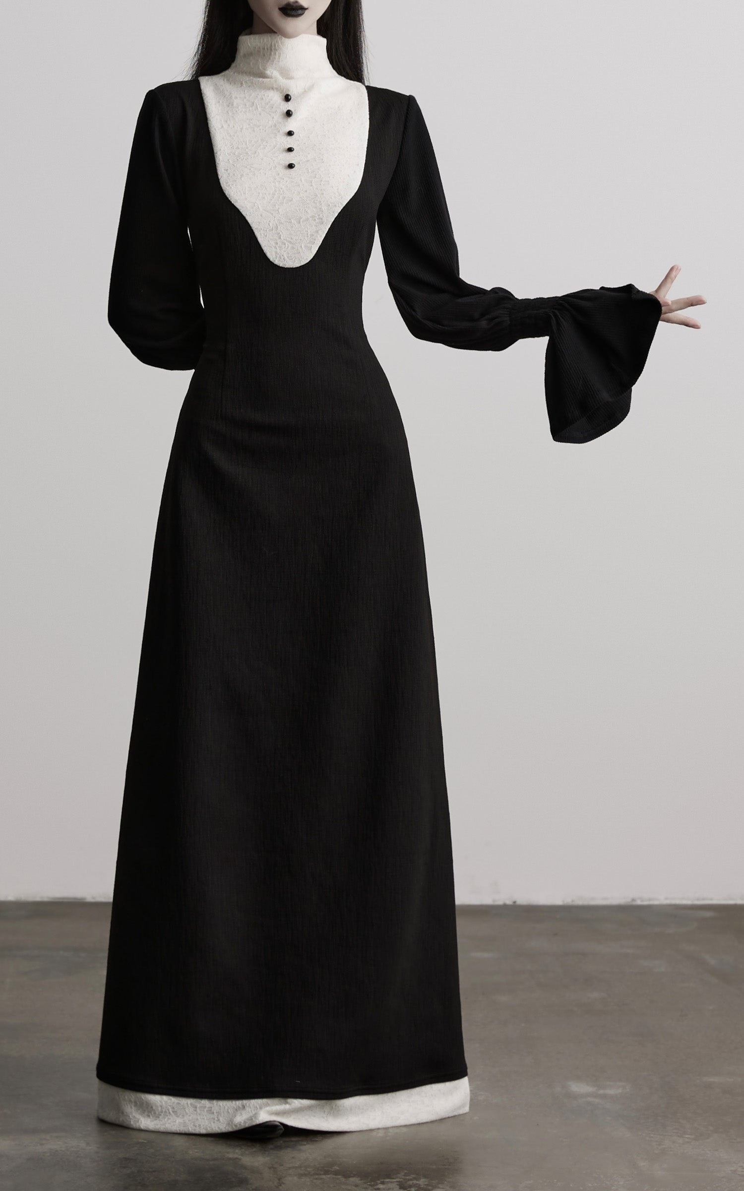 front view of black contrast panel dress highlighting skirt and cuffs