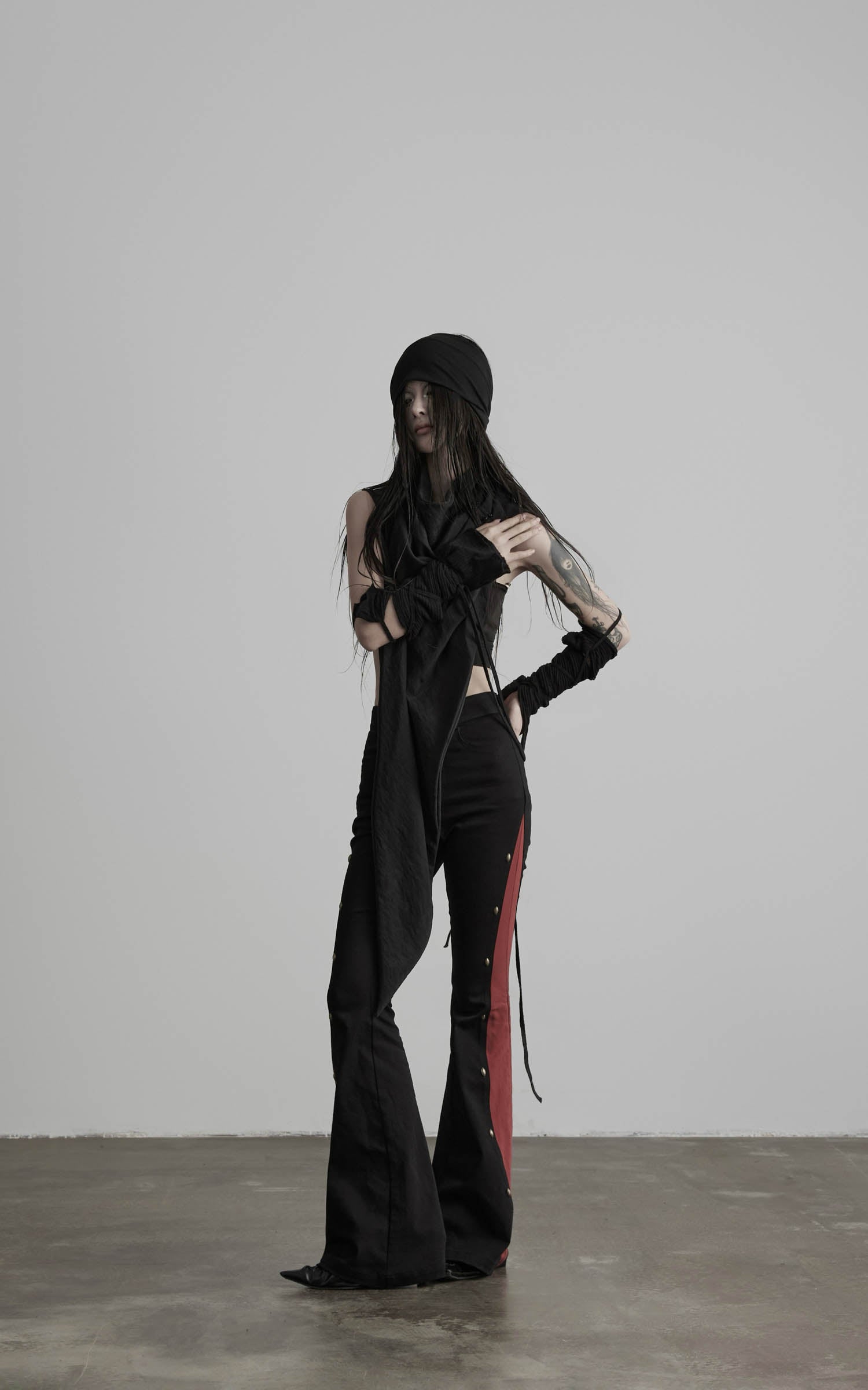 angled front view of black flared pants with red side contrast