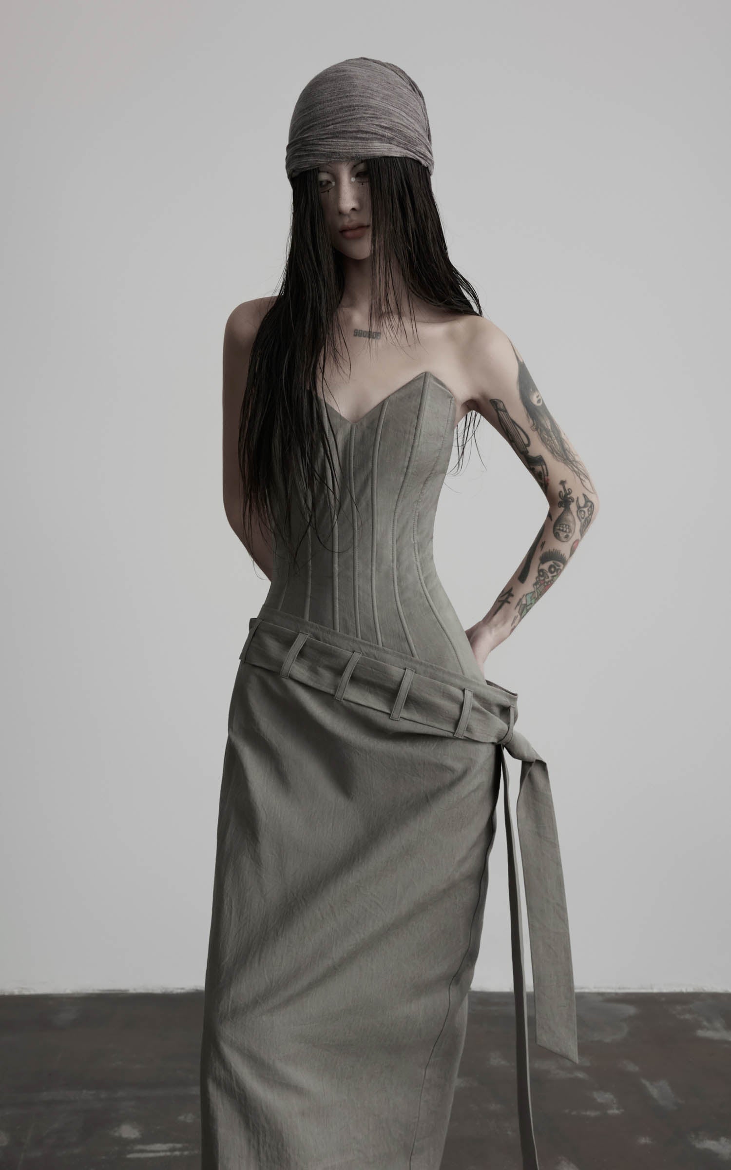 Close-up of gray corset wrap maxi dress with stitched bodice and wrap belt