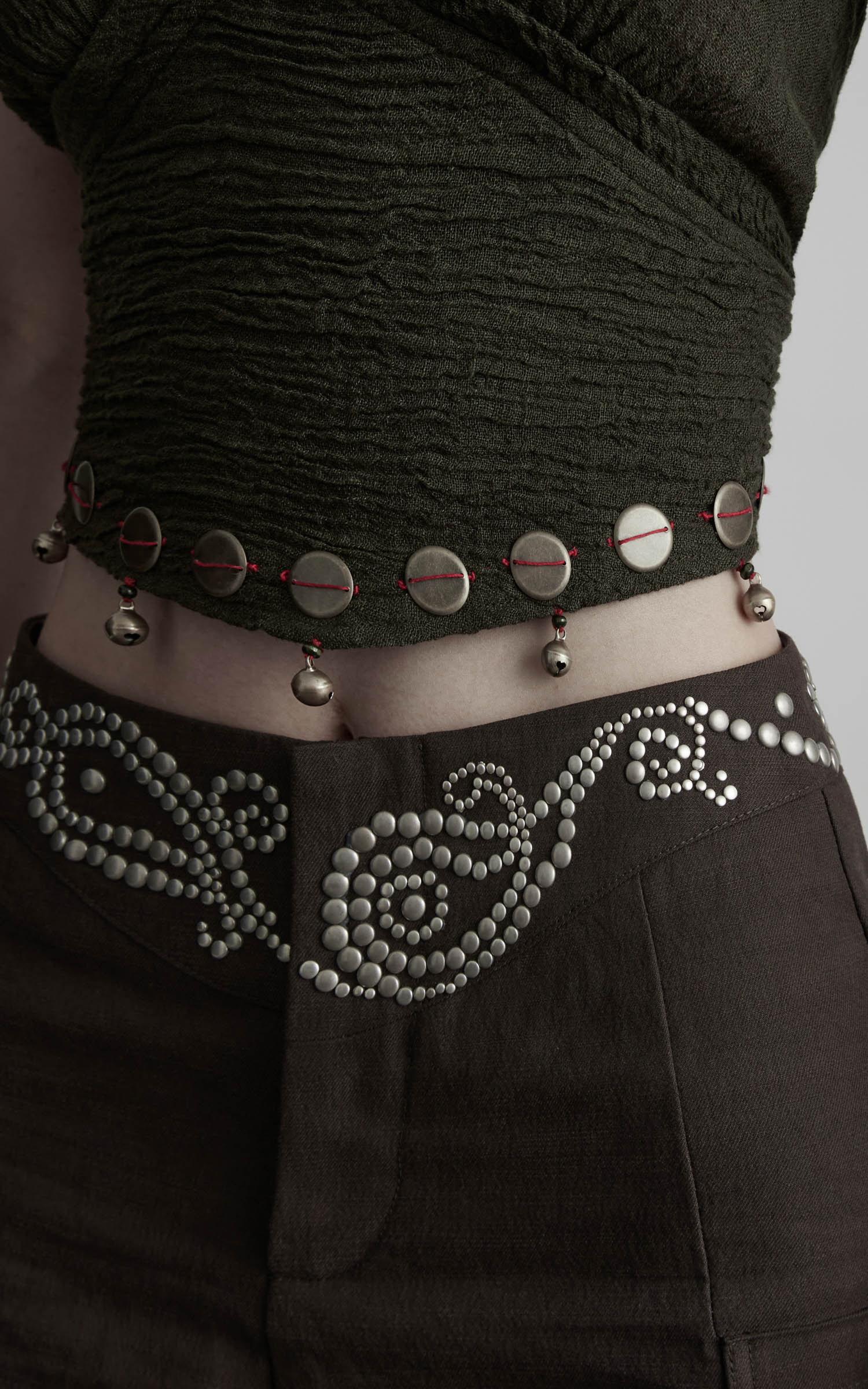 Close-up of rhinestone waistband detail on dark coffee wide leg pants