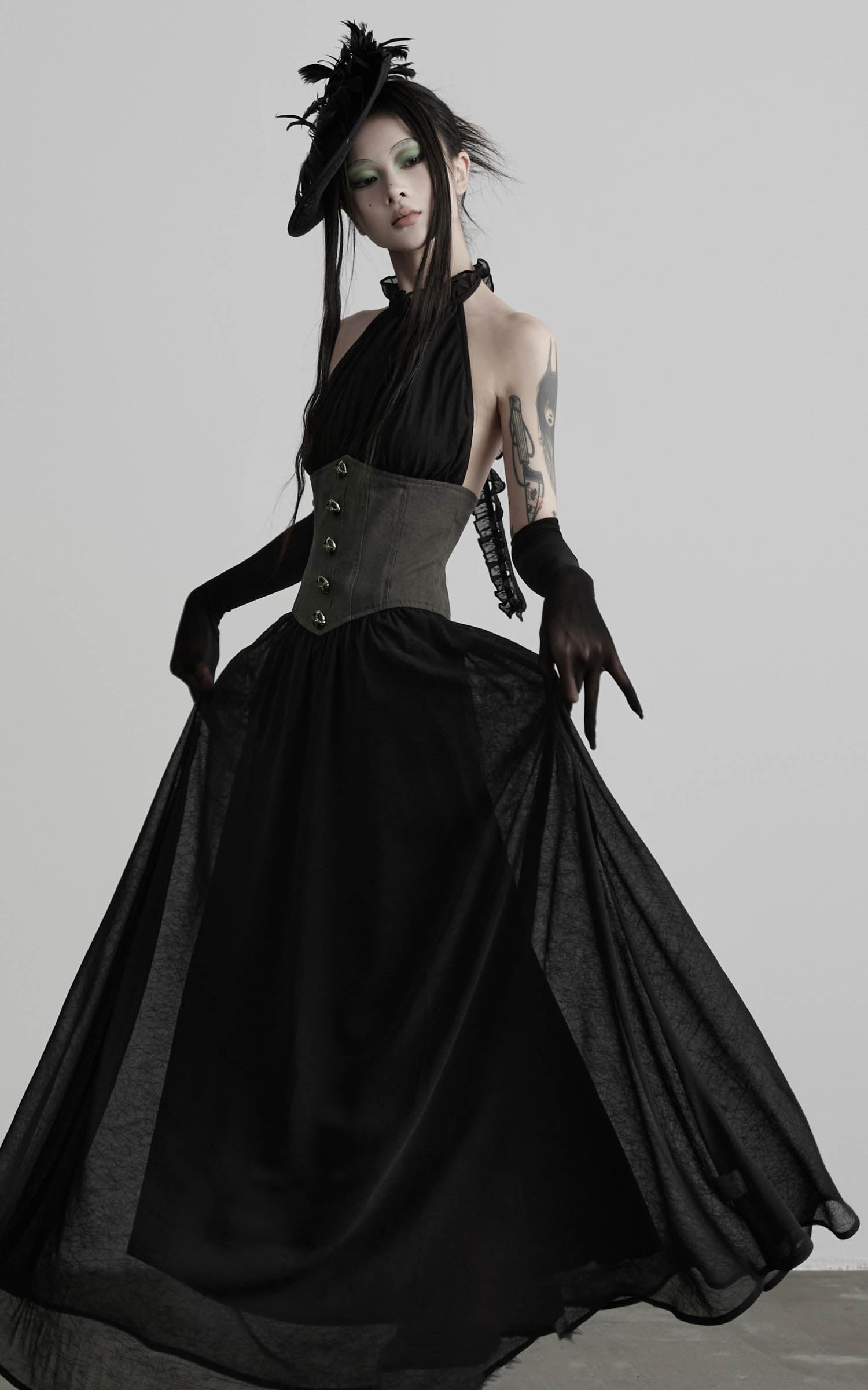 Black gathered halter corset maxi dress with airy skirt drape angled view
