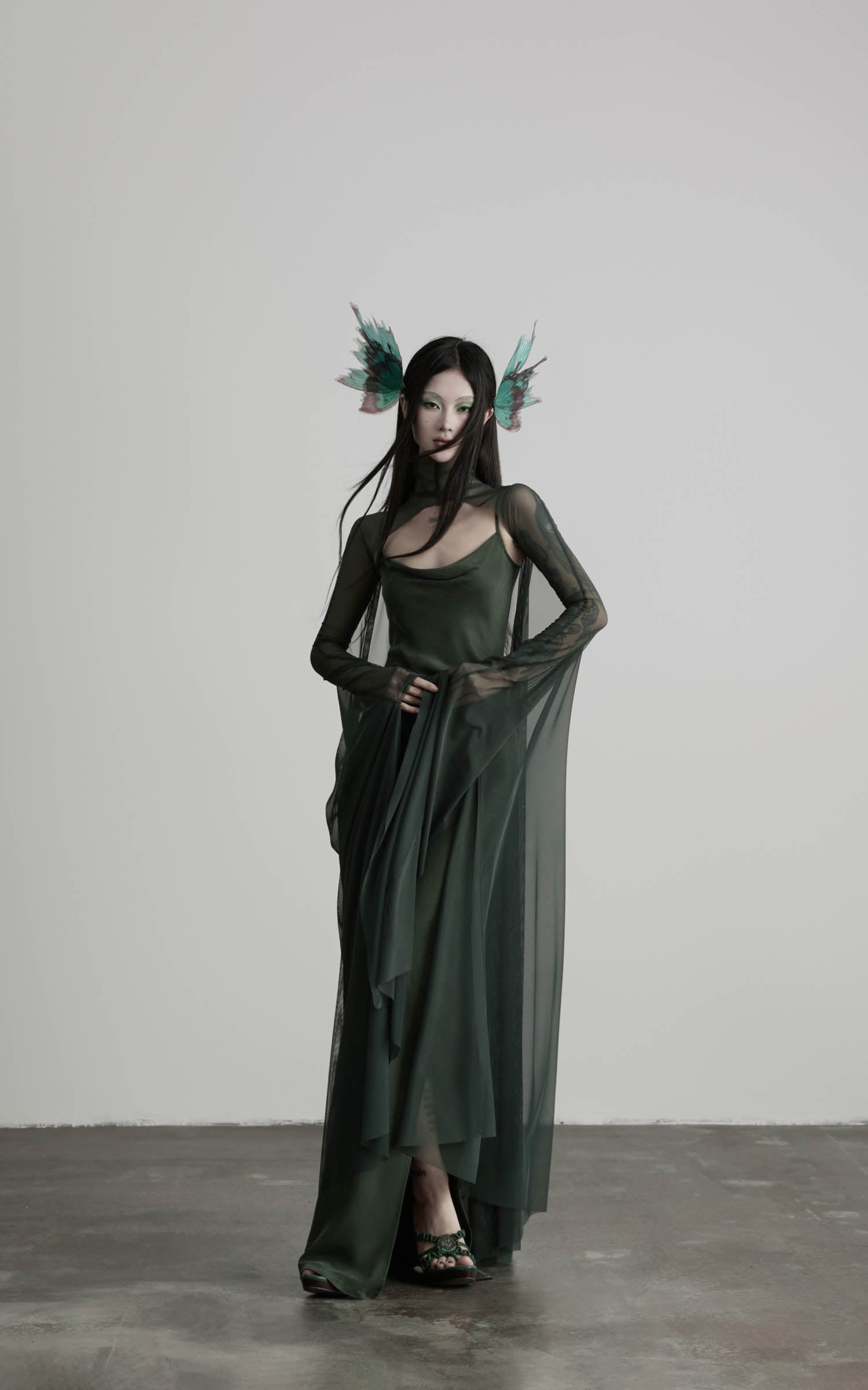 Dark green slip maxi dress with draped mesh cape angled view