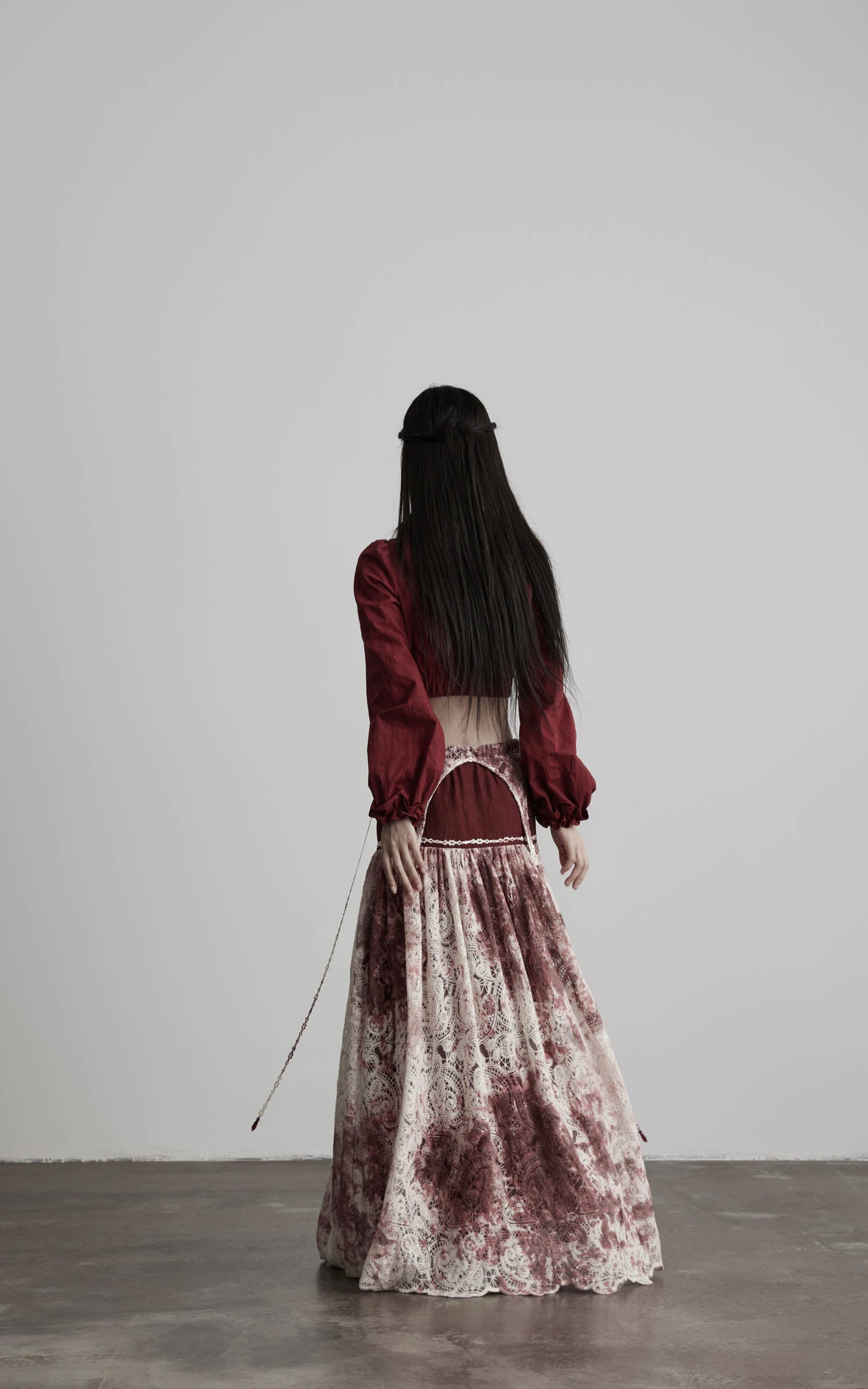 back view of low rise maxi skirt in burgundy and ivory with open waist detail