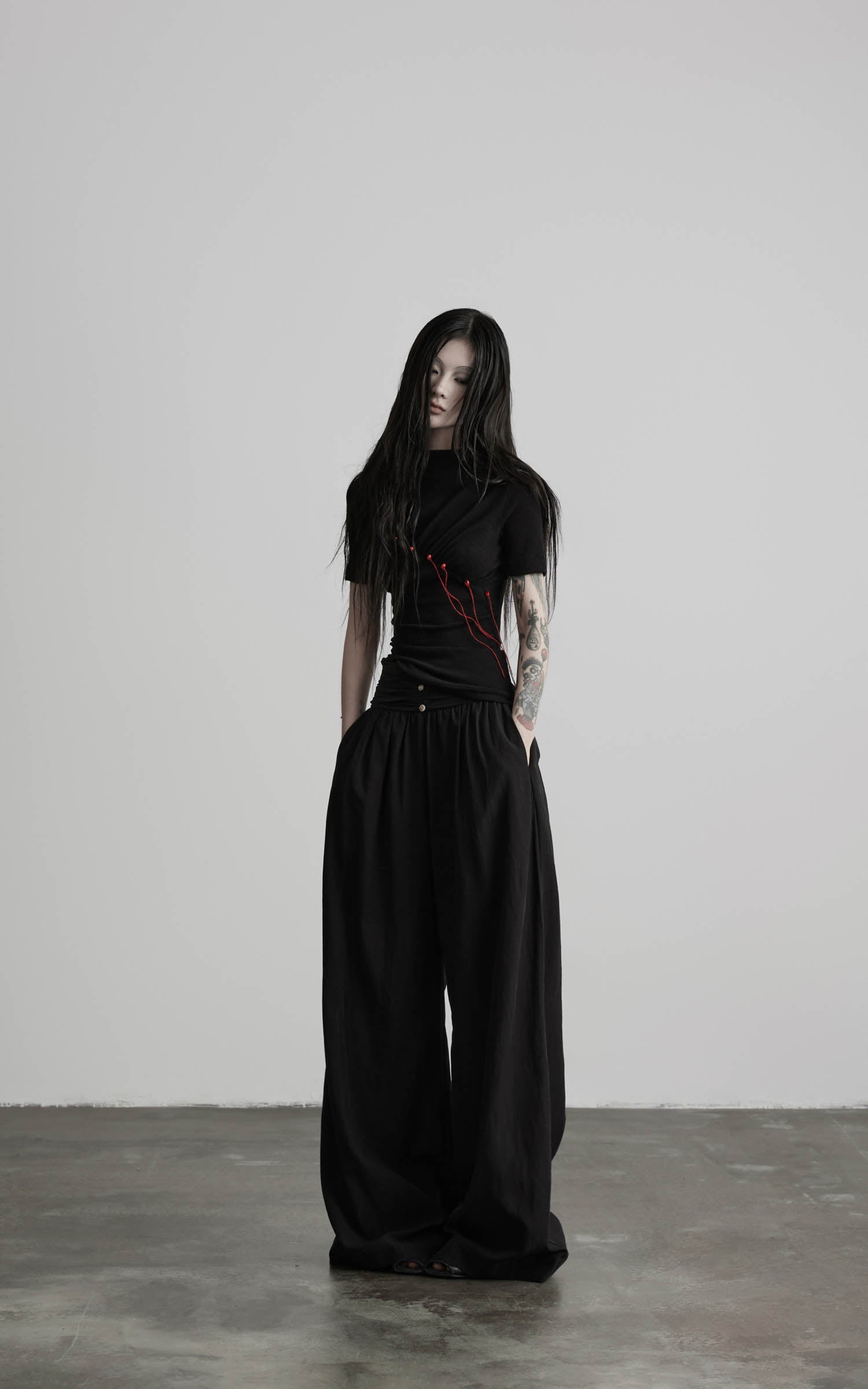 Black mock neck ruched knit T-shirt with red thread accents front view