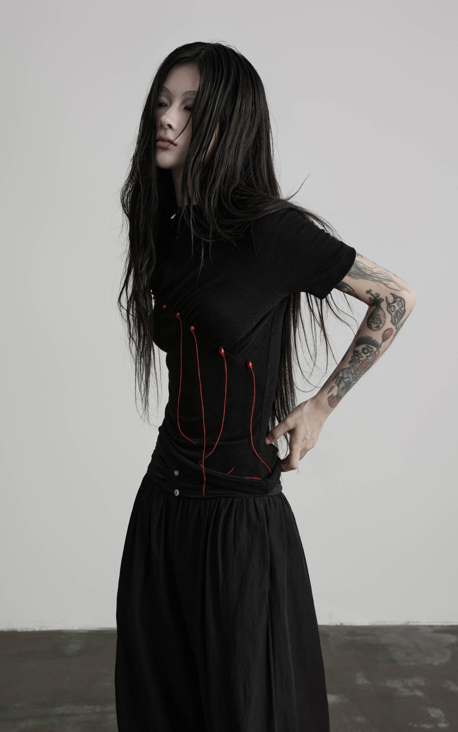 Black mock neck ruched knit T-shirt with red thread detail side view