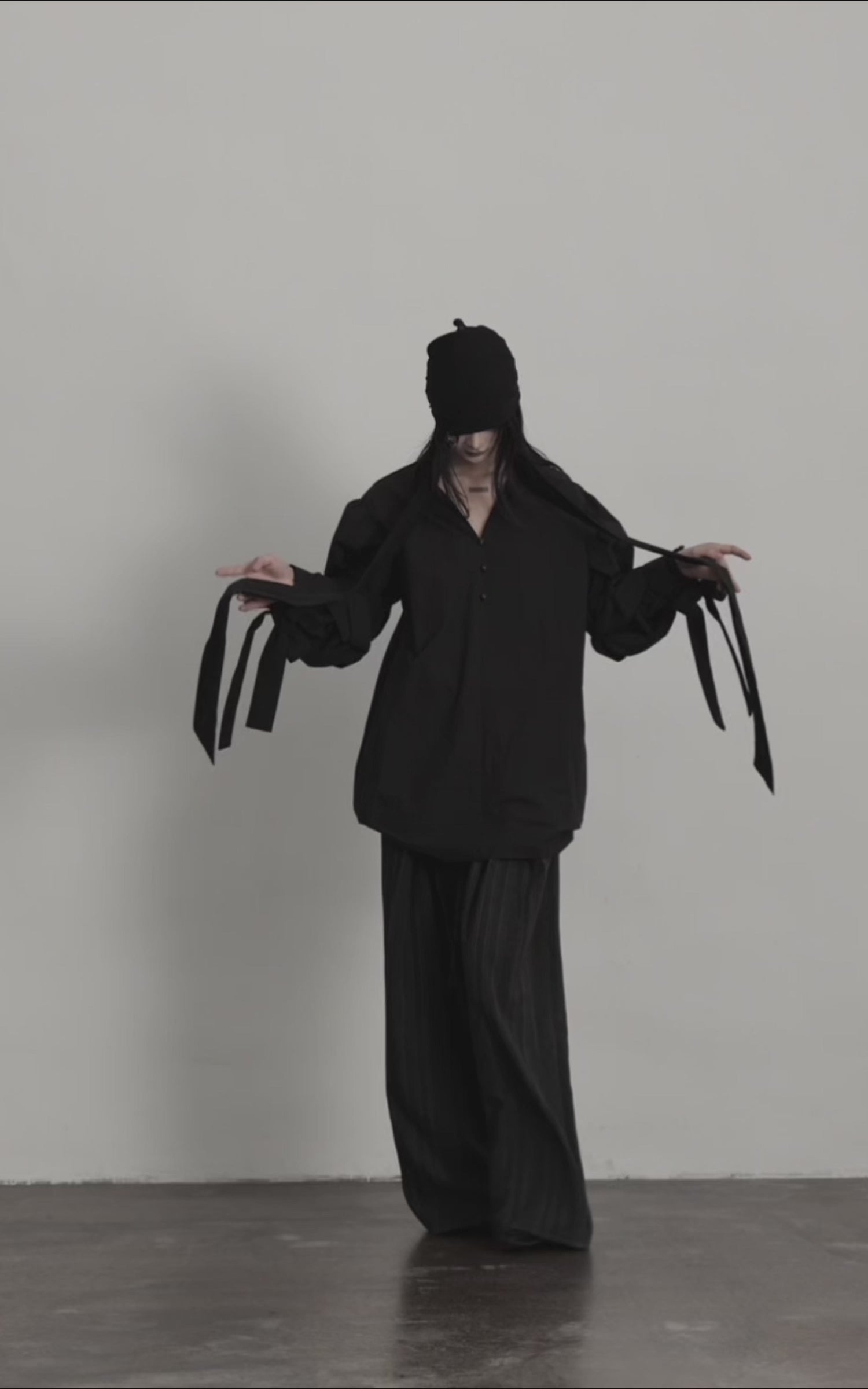 Load video: DOINDULGE Sculptural Ribbon Sleeve High Neck Shirt