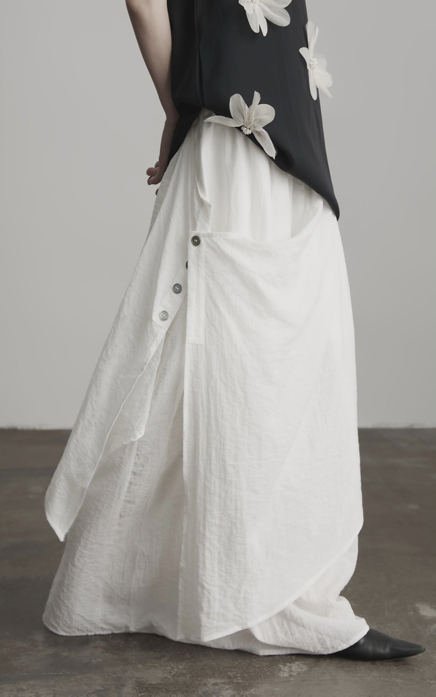 Load video: INDULGE Asymmetric Draped Skirt with Side Button Detail and Textured Cotton Layers
