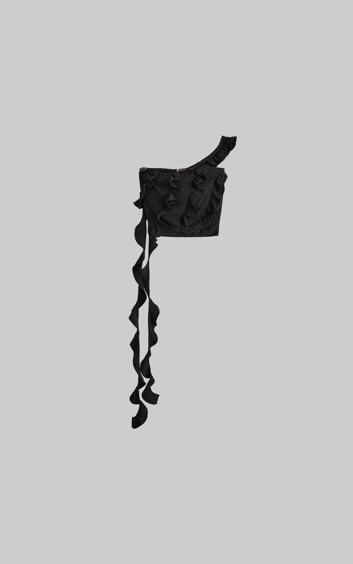 front view of black ruffled off shoulder crop top laid flat with long ties