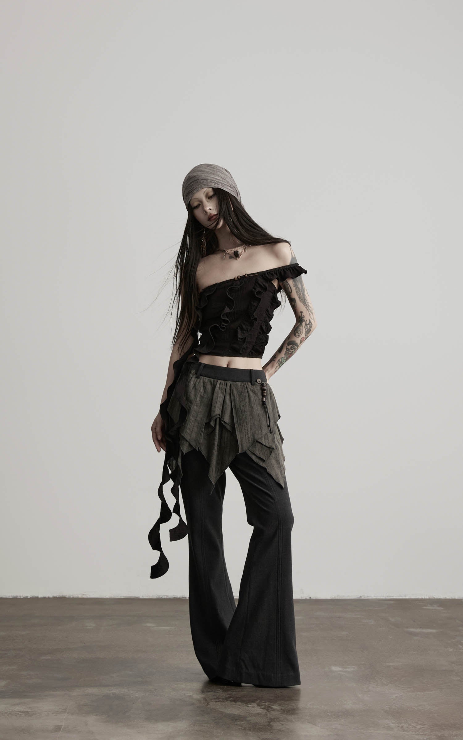 front angled view of black ruffled off shoulder crop top with relaxed fit