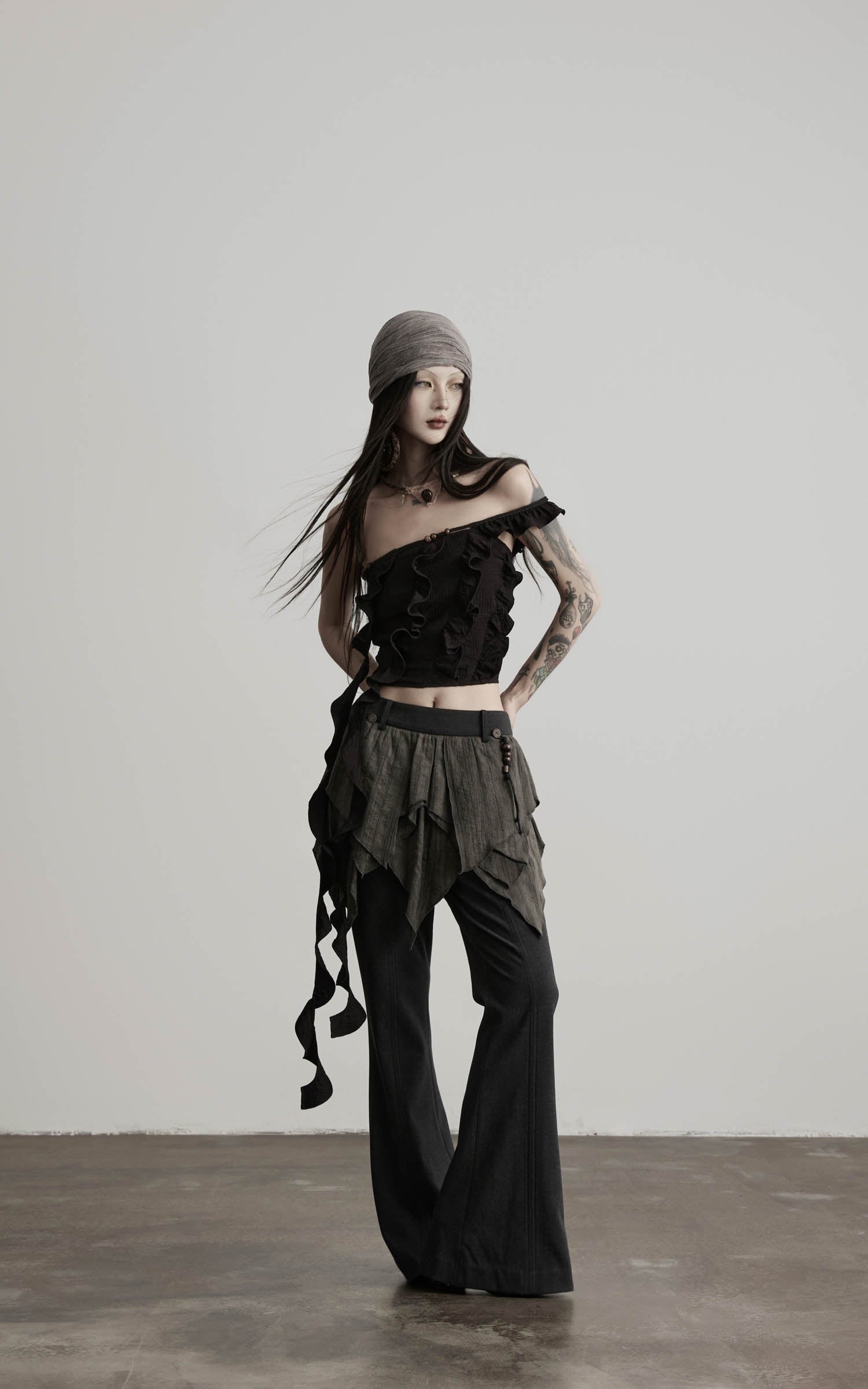 side view of black ruffled off shoulder crop top with flowing drape