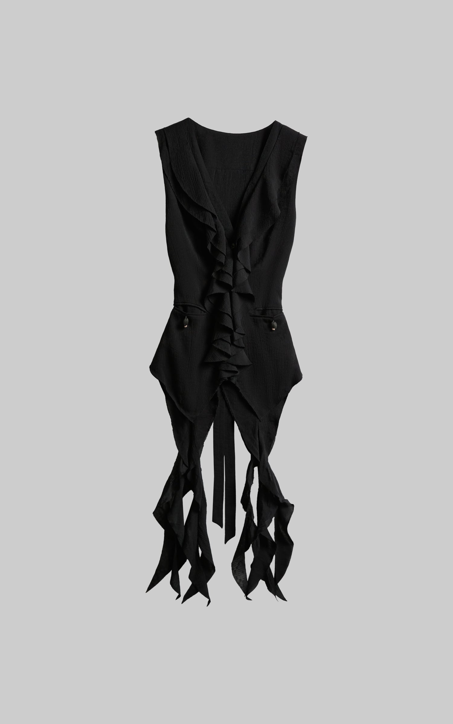 front view of black ruffled tie vest laid flat with deconstructed ties