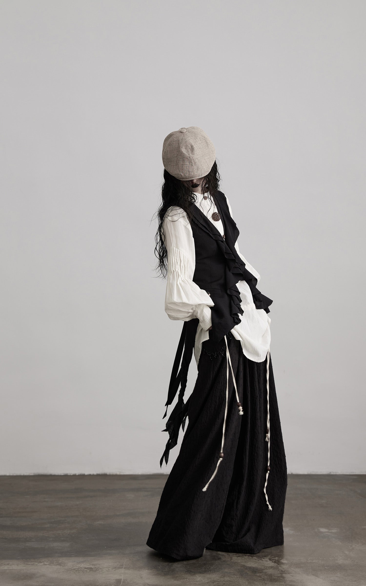side view of black ruffled tie vest with flowing tie details