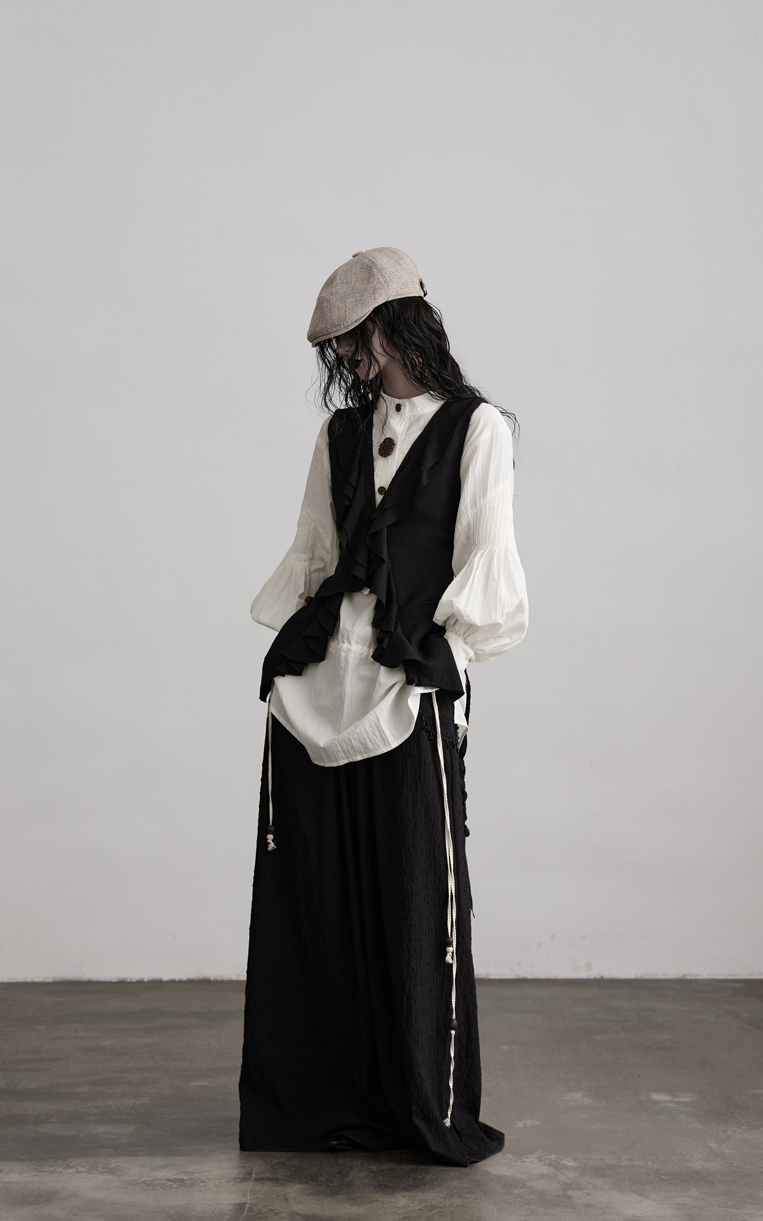 side view of black ruffled tie vest with layered silhouette