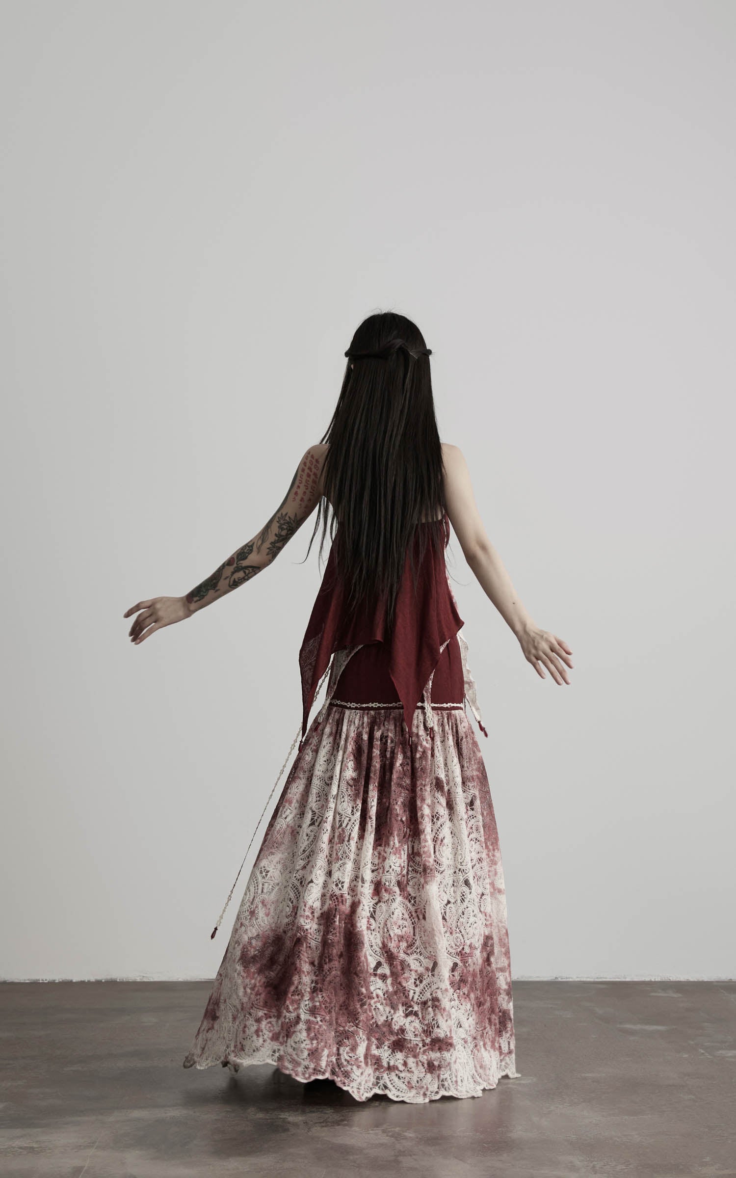 back view of red strapless top with layered lace and flowing skirt