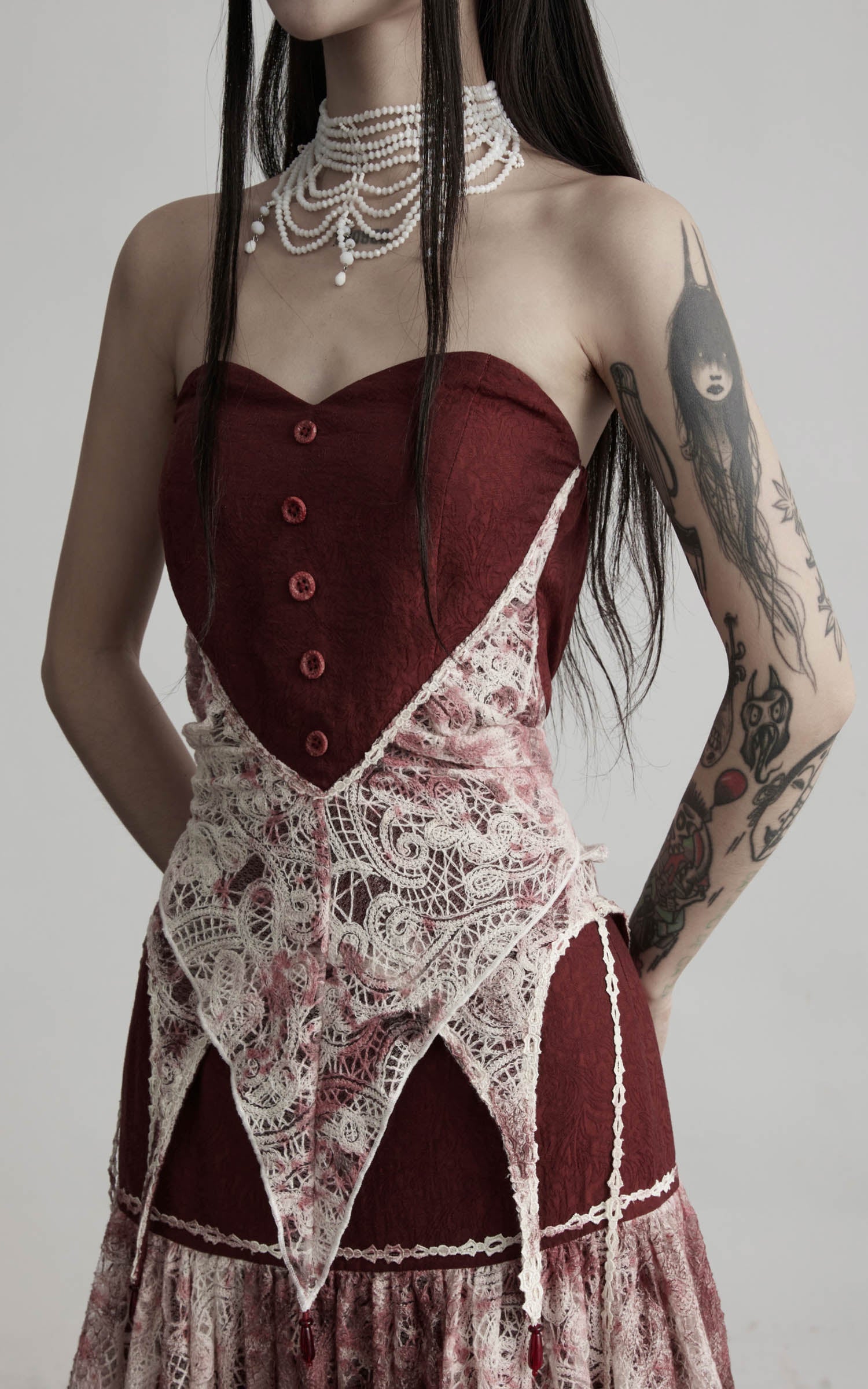 close-up of red strapless top with buttons and lace waist overlay