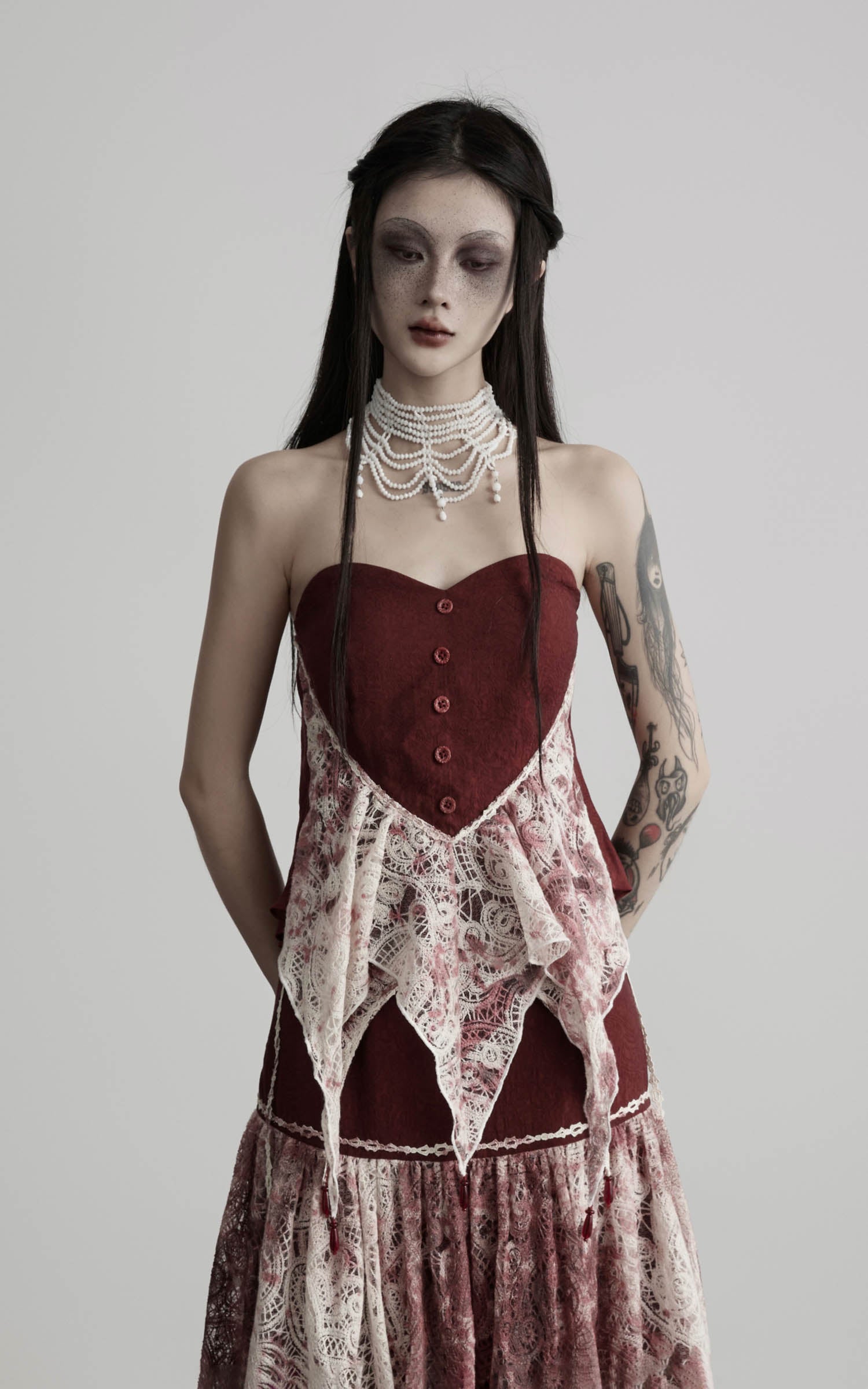 close-up of red strapless top with lace overlay and button detail