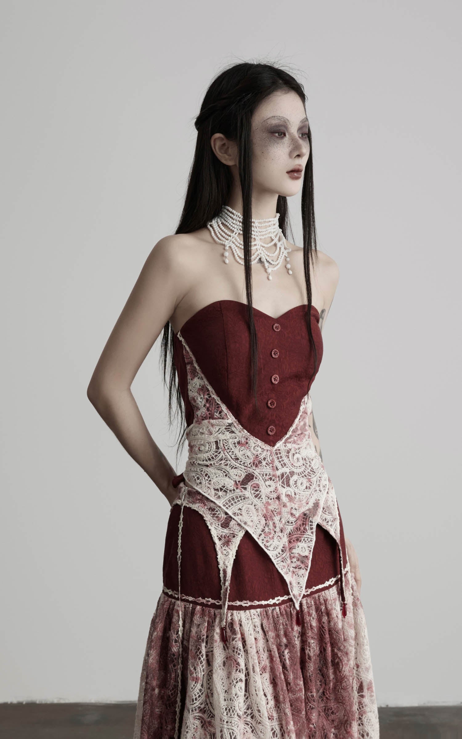 side view of red strapless top with structured bodice and lace detail
