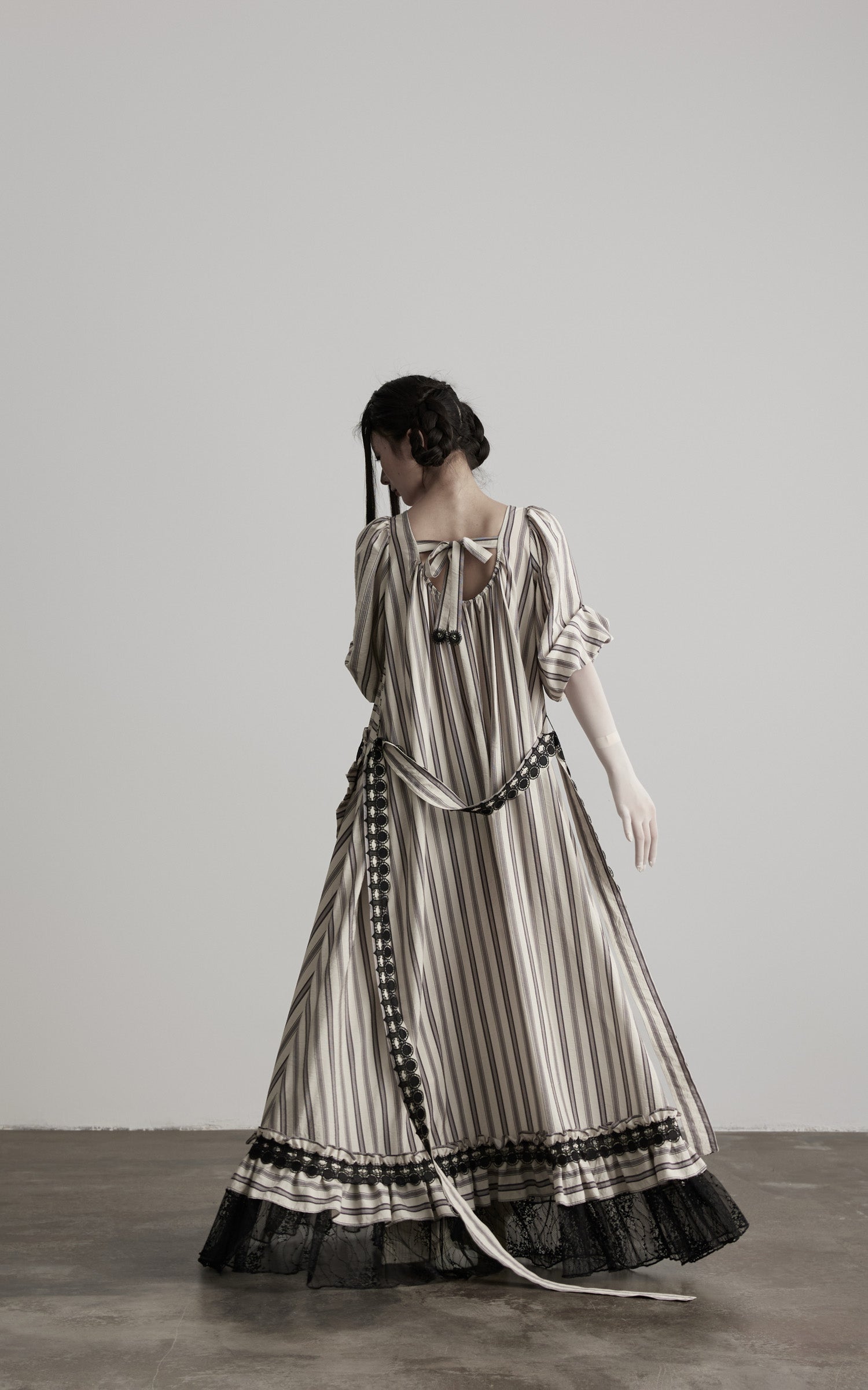 back view of beige striped maxi dress with flowing hem