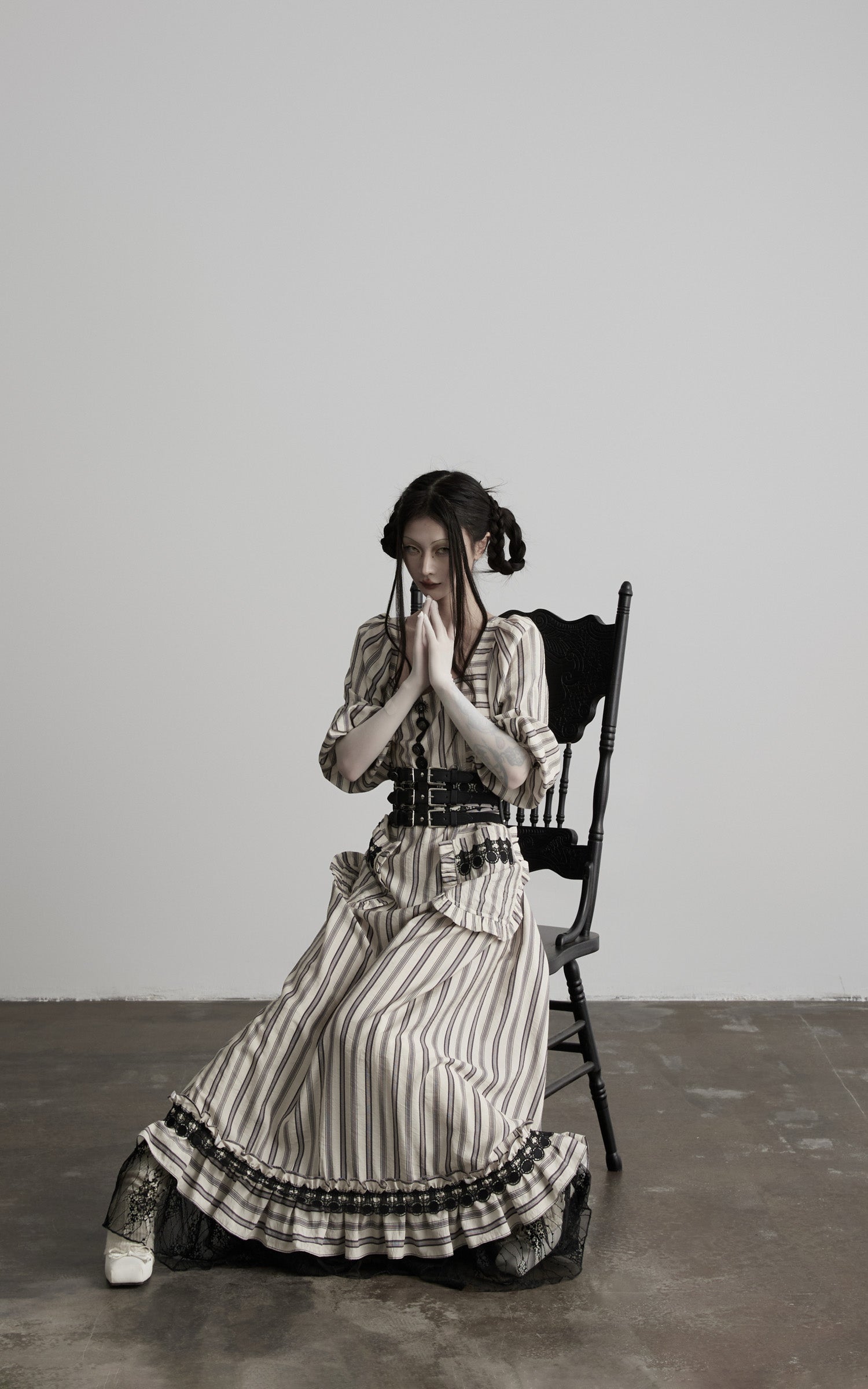 side view of beige striped maxi dress with lace hem seated