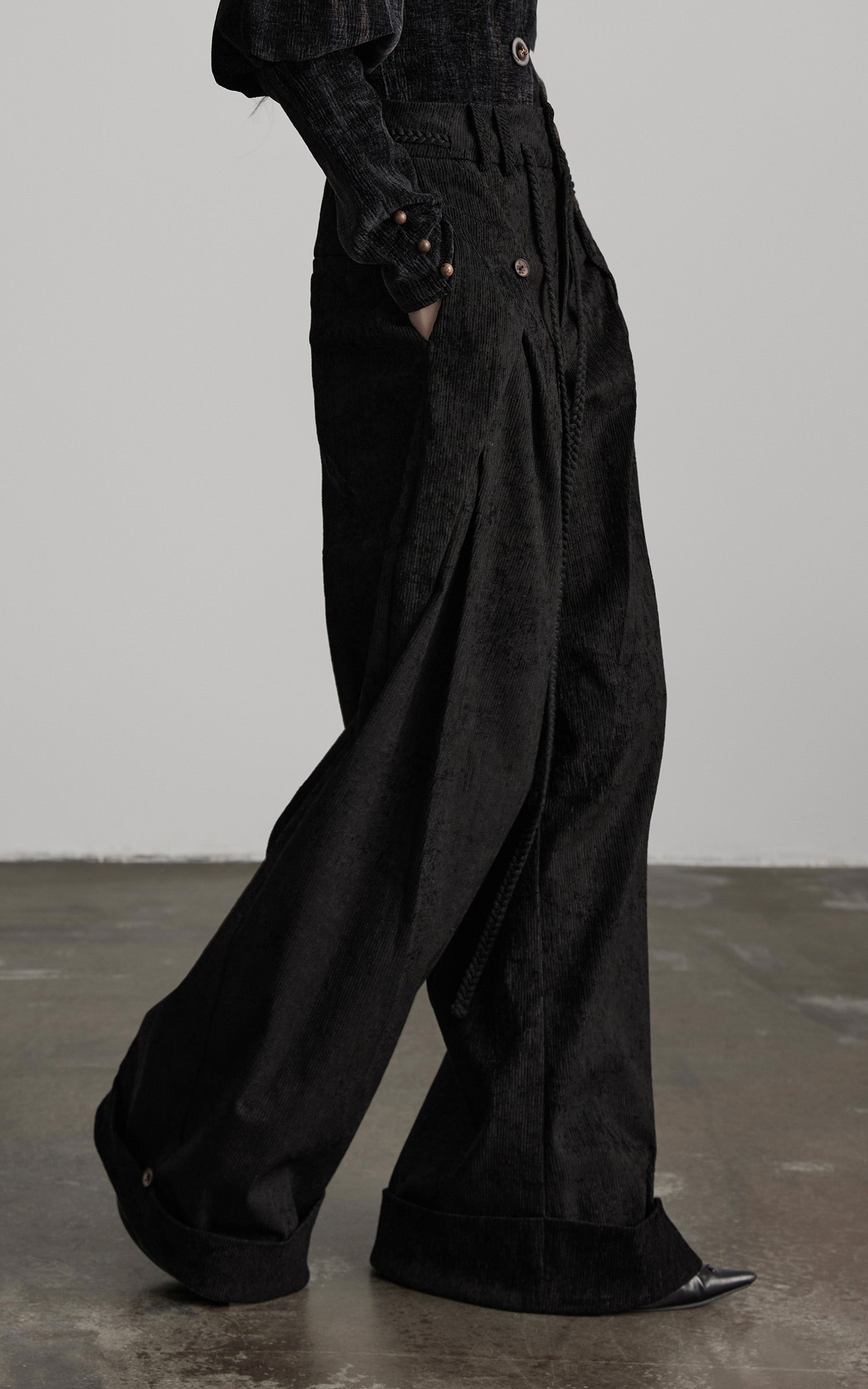 side view of black textured wide leg pants with extended wide hem