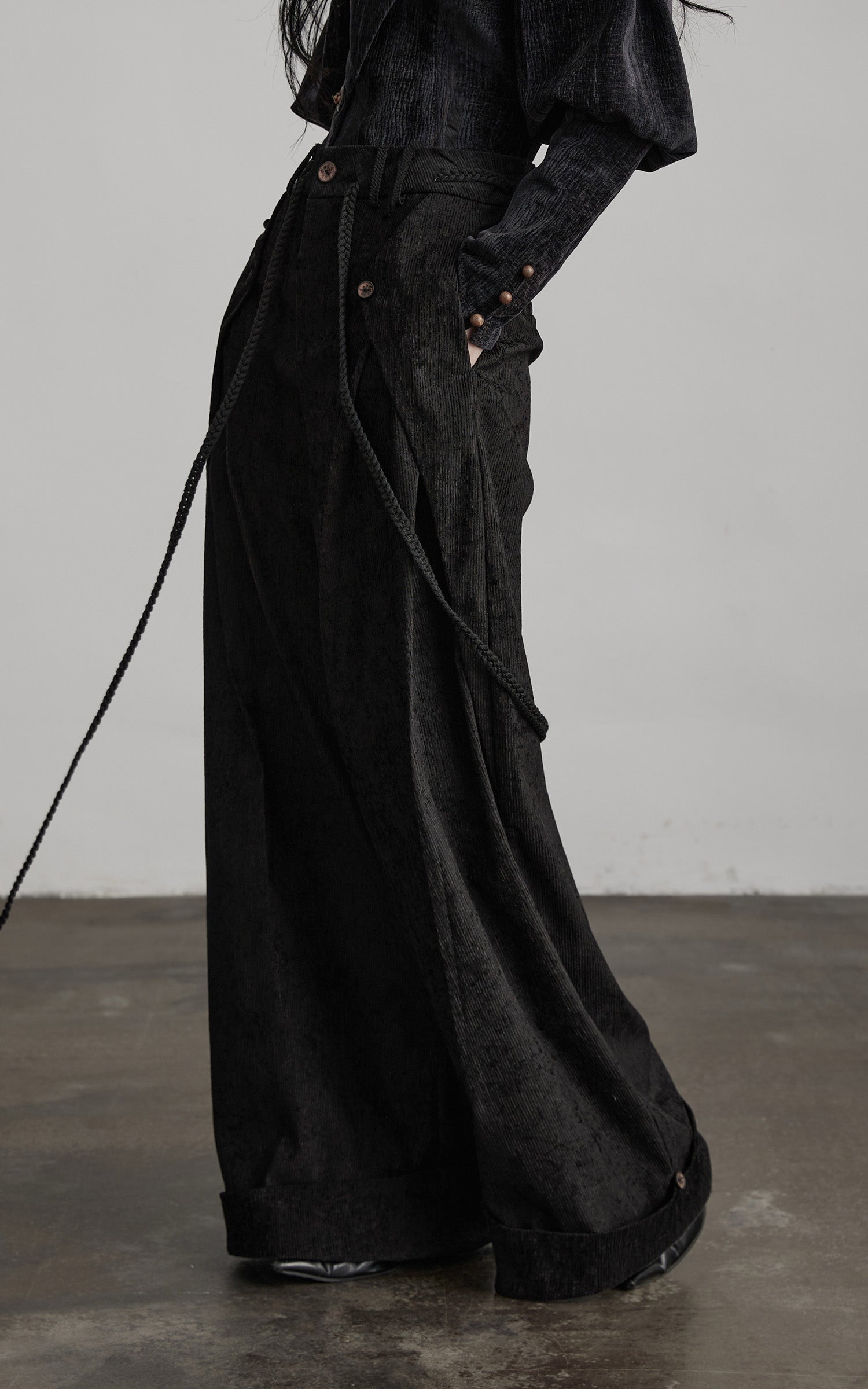side view of black textured wide leg pants with fluid movement