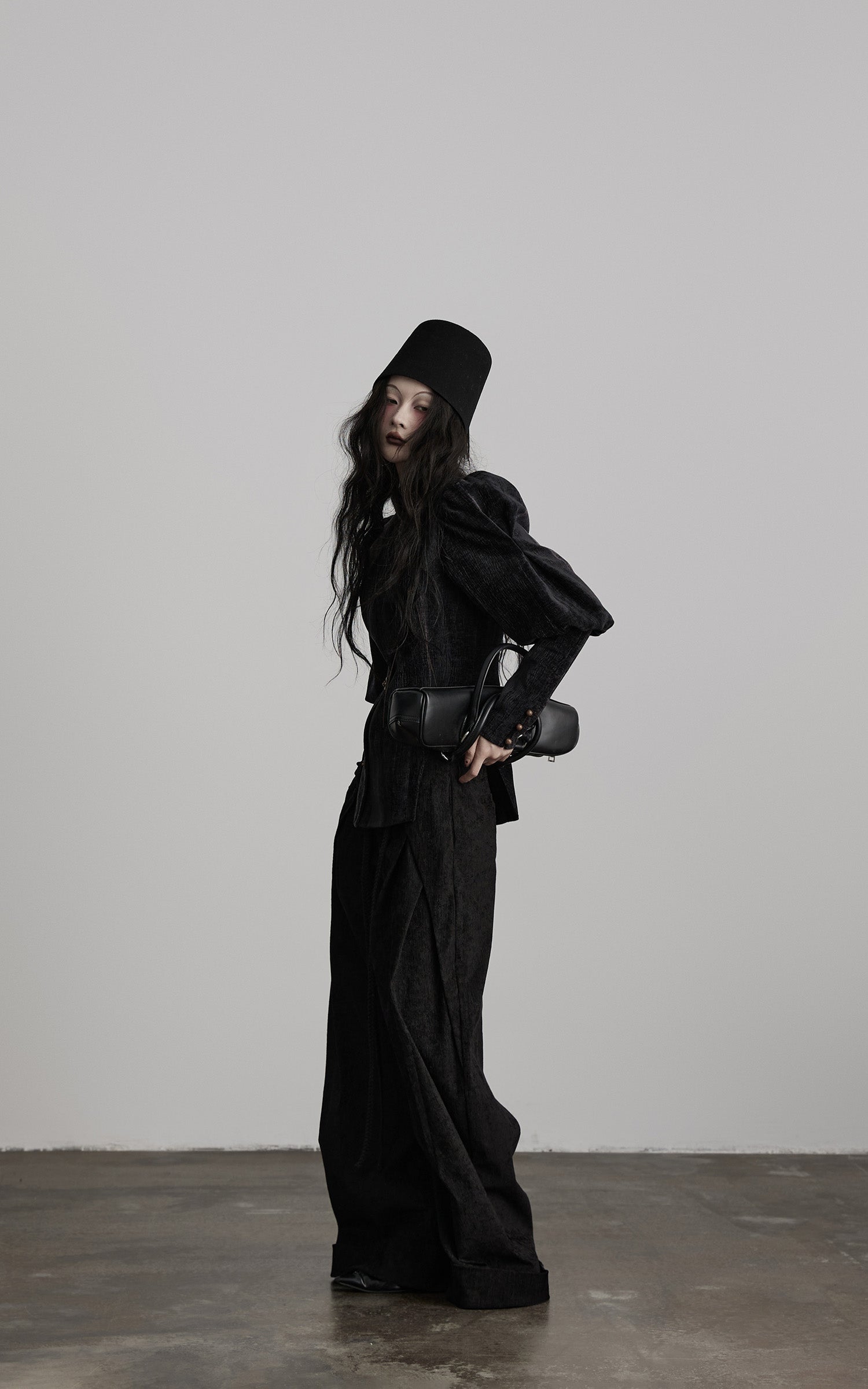 side view of black textured wide leg pants with flowing draped panels