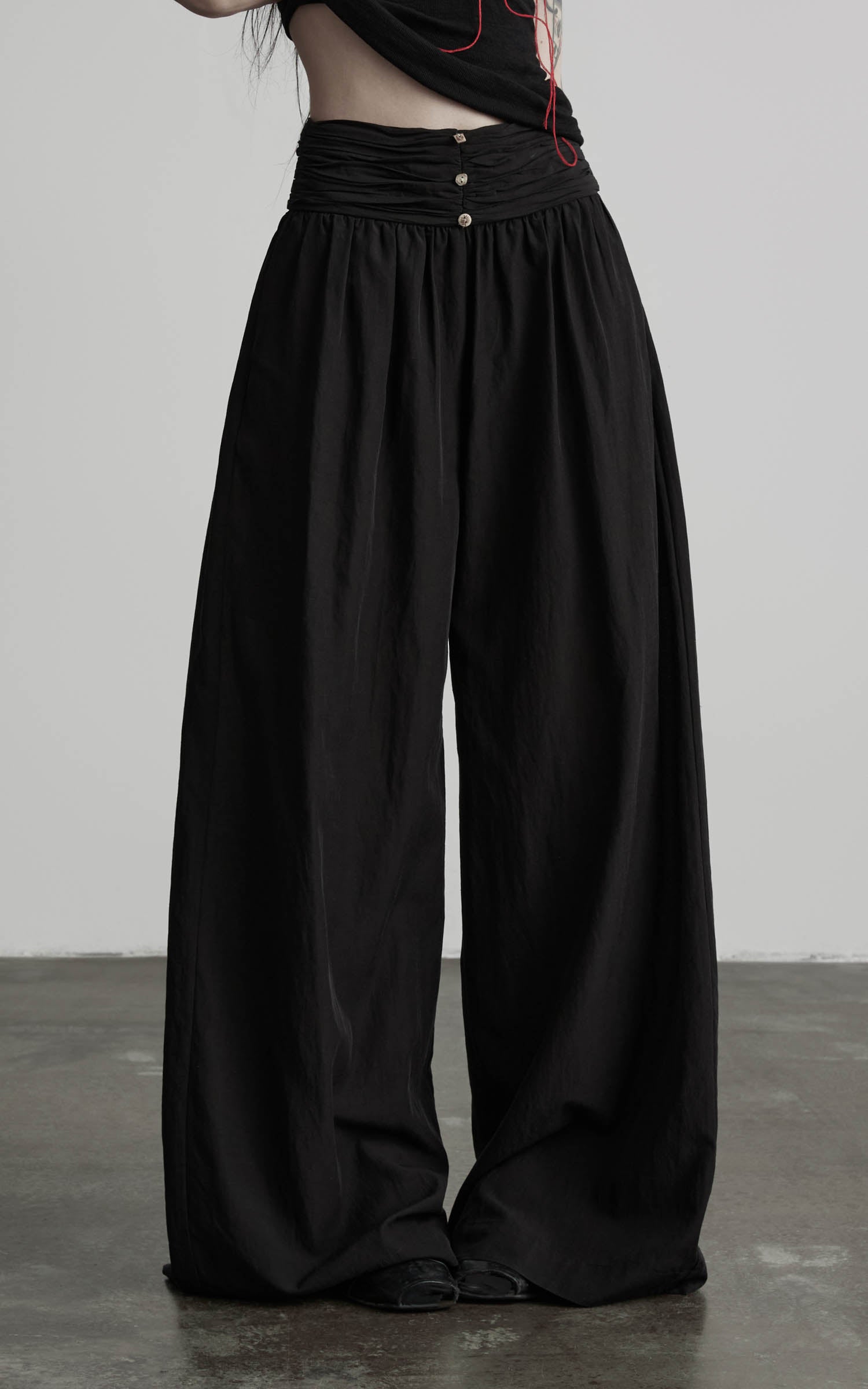 Close-up of black wide leg gathered waist pants with ruched waistband