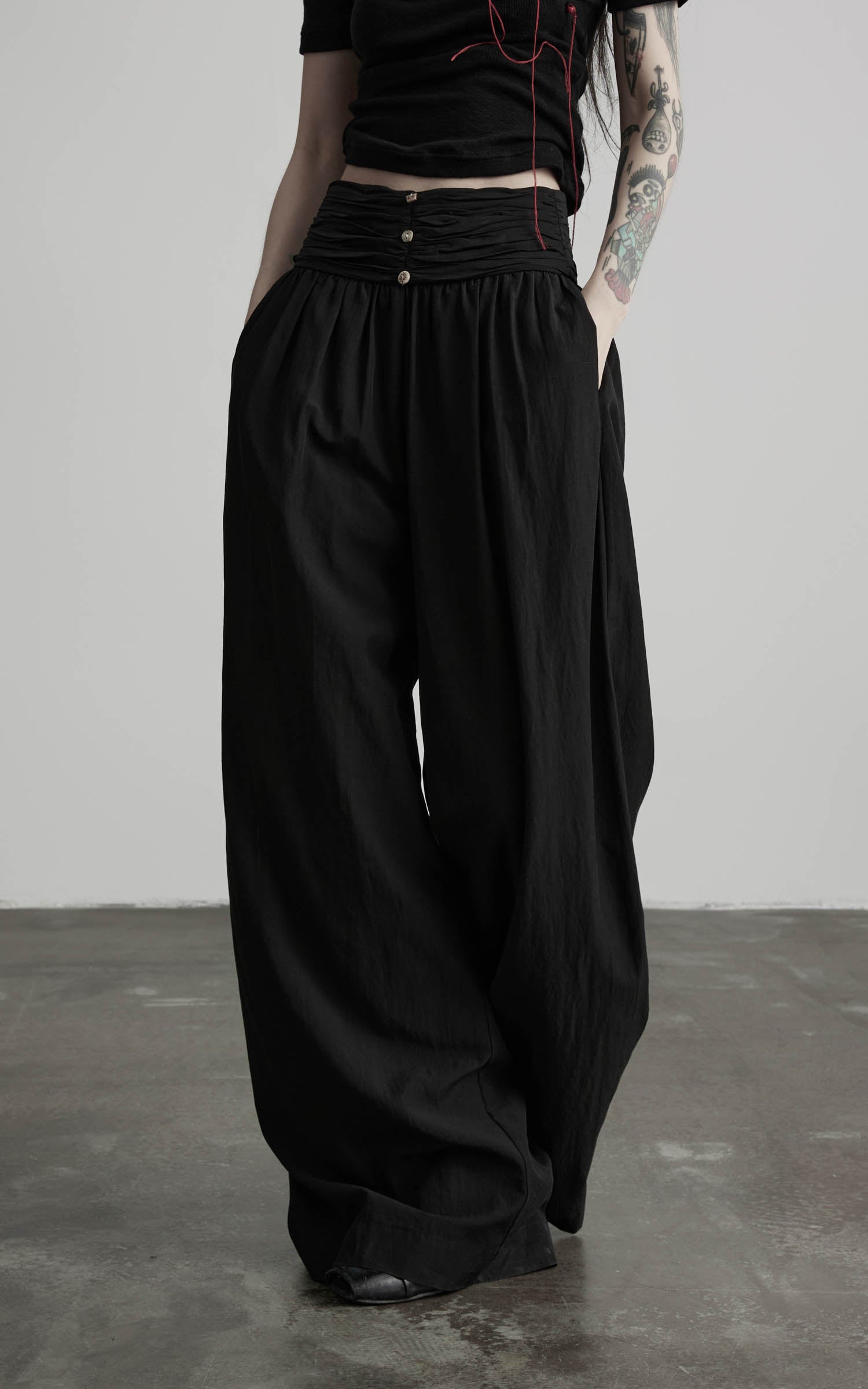 Close-up of black wide leg gathered waist pants with side pockets
